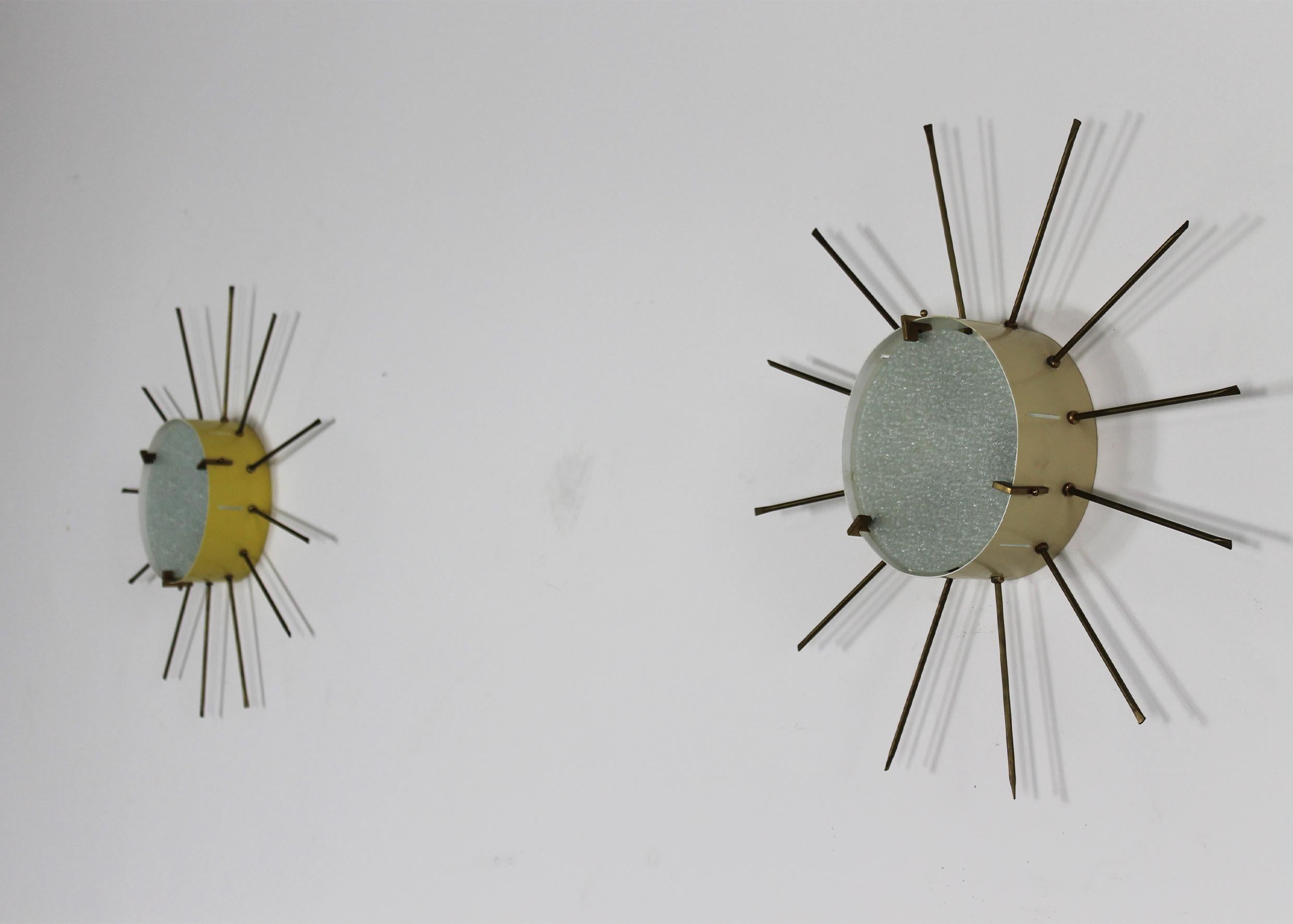 Set of two wall lamps (they can also be used as ceiling lamps as well) with structure in lacquered metal (one is in a beige shade and one is in a brilliant yellow shade) stamped glass and details and hand-made spikes in brass. 

These lamps were