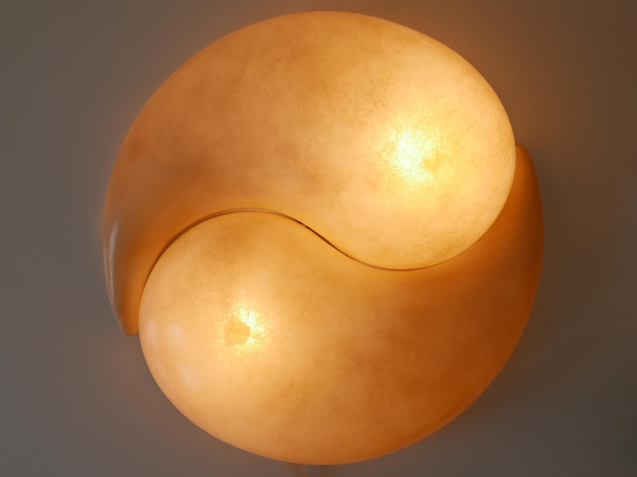 Set of two rare and elegant wall lamps or sconces 'Chakra'. Designed by Gregorio Spini for Kundalini, Italy, 2000s. Makers label on the bulb socket.

Executed in fiberglass and metal, each lamp needs 1 x E27 / E26 Edison screw fit bulb, is wired,