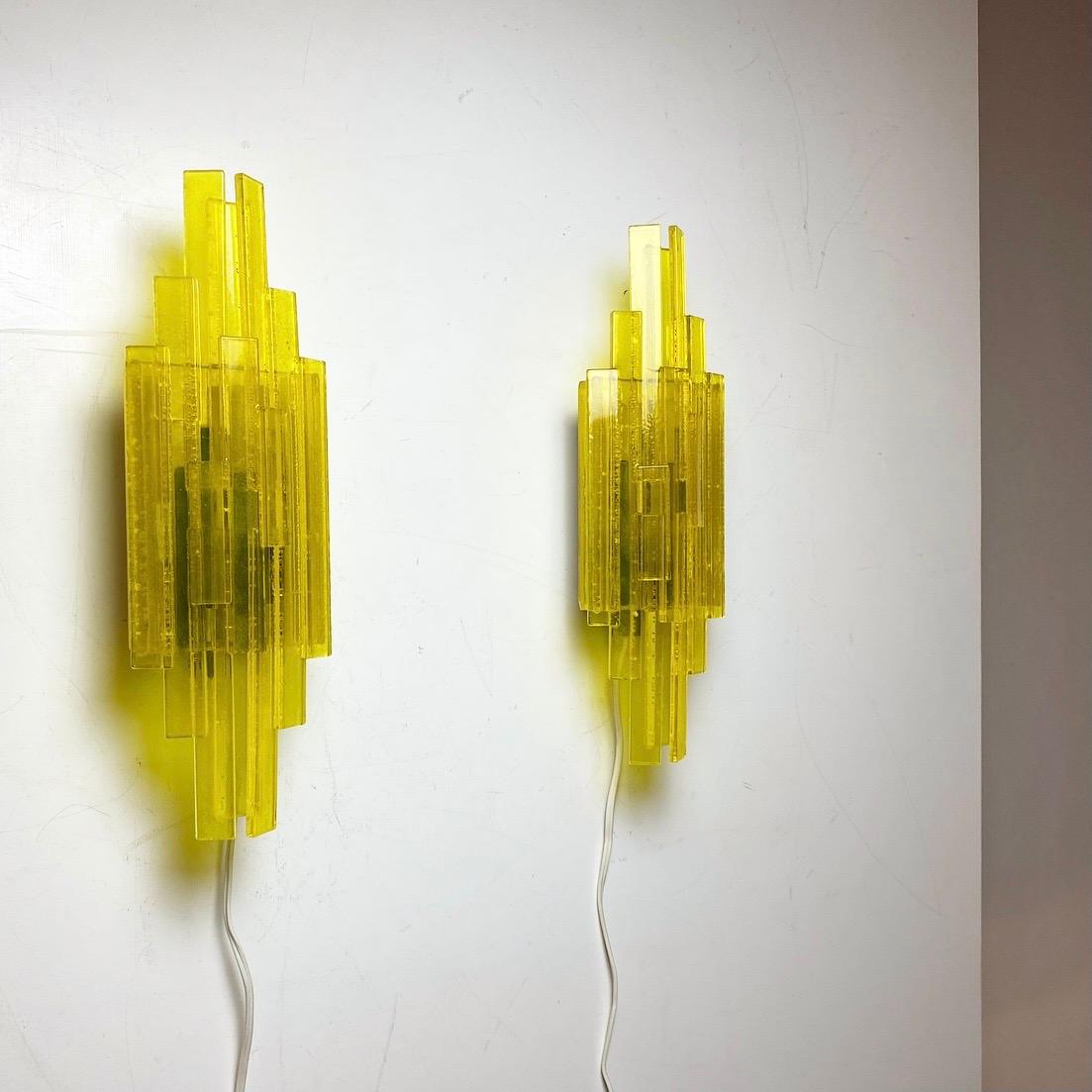 Beautiful iconic and rare set of wall lights by Claus Bolby, Denmark 1970s. 

Finding an original set of Claus Bolby in yellow color and never restored before is quite rare. 

These lights are made of yellow transparent plastic sticks. Gives a