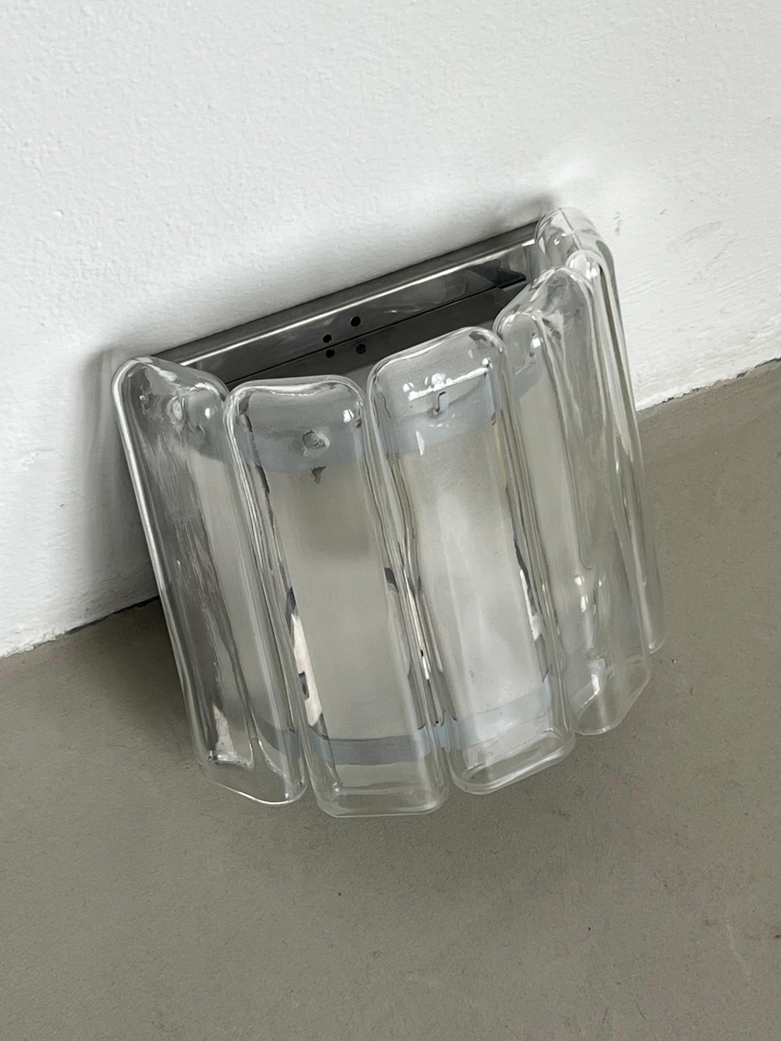 Sculptural Italian glass Sconces - Wall Lights Set - Murano Appliques - Lighting Art

Set of two  glass sconces with a chromed metal semicircular cron hiding the wiring and light holder. Well made, they consist of five crushed glass pipes  tubular