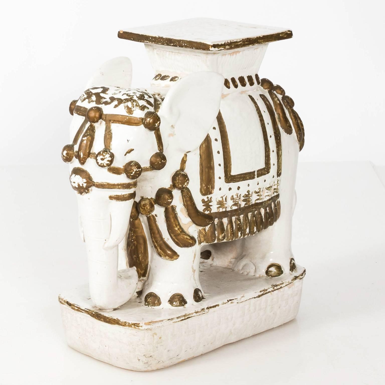 Set of two white painted ceramic elephant garden stools with painted gold highlights, circa mid-20th century.