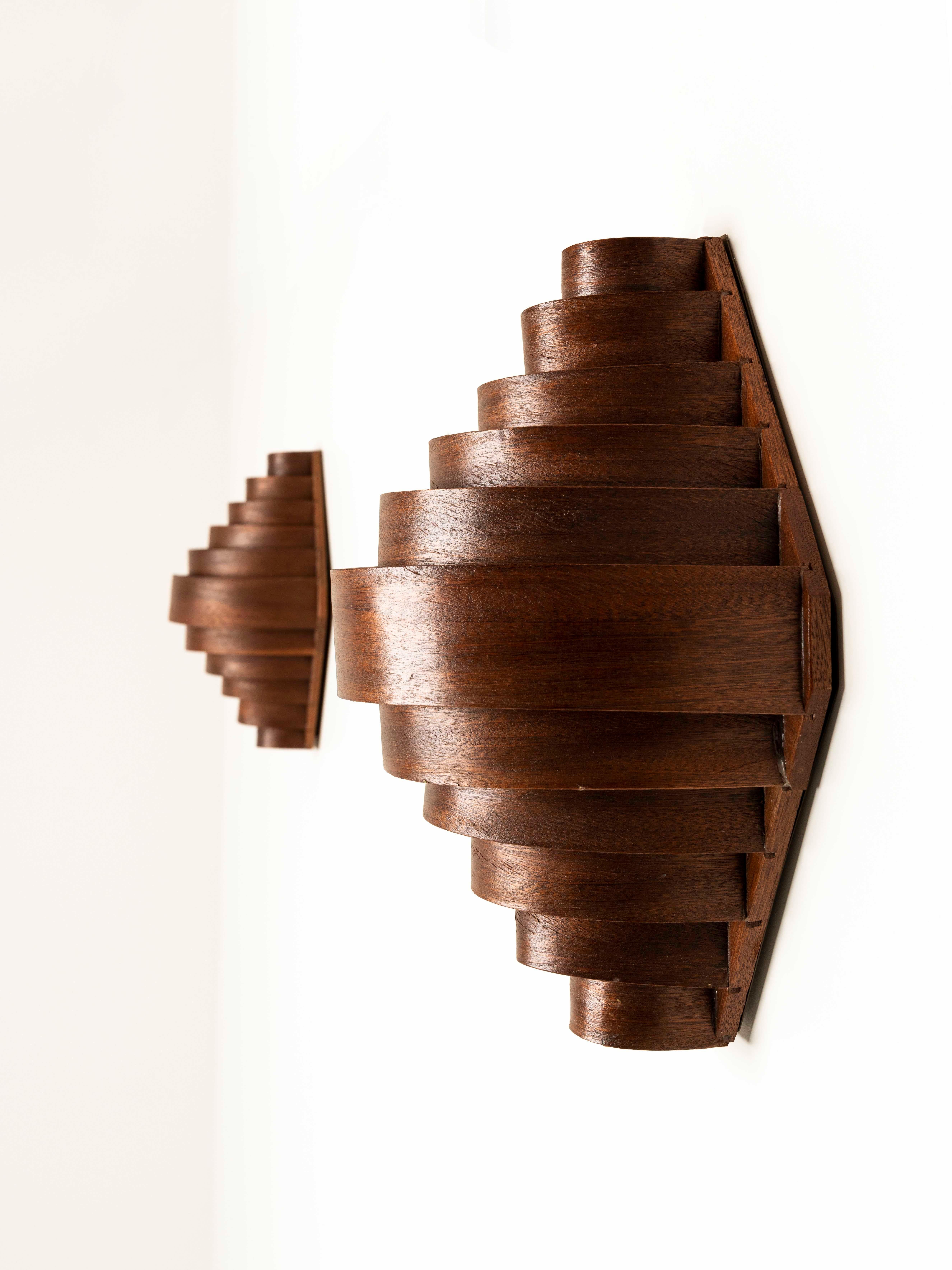 Beautiful set of two wooden wall lights by Hans-Agne Jakobsson from Sweden, the 1960s. These lamps are designed with bended wood slats and give the lamps a great warm look and feel. The wood can be removed to find a metal base with a fitting. The