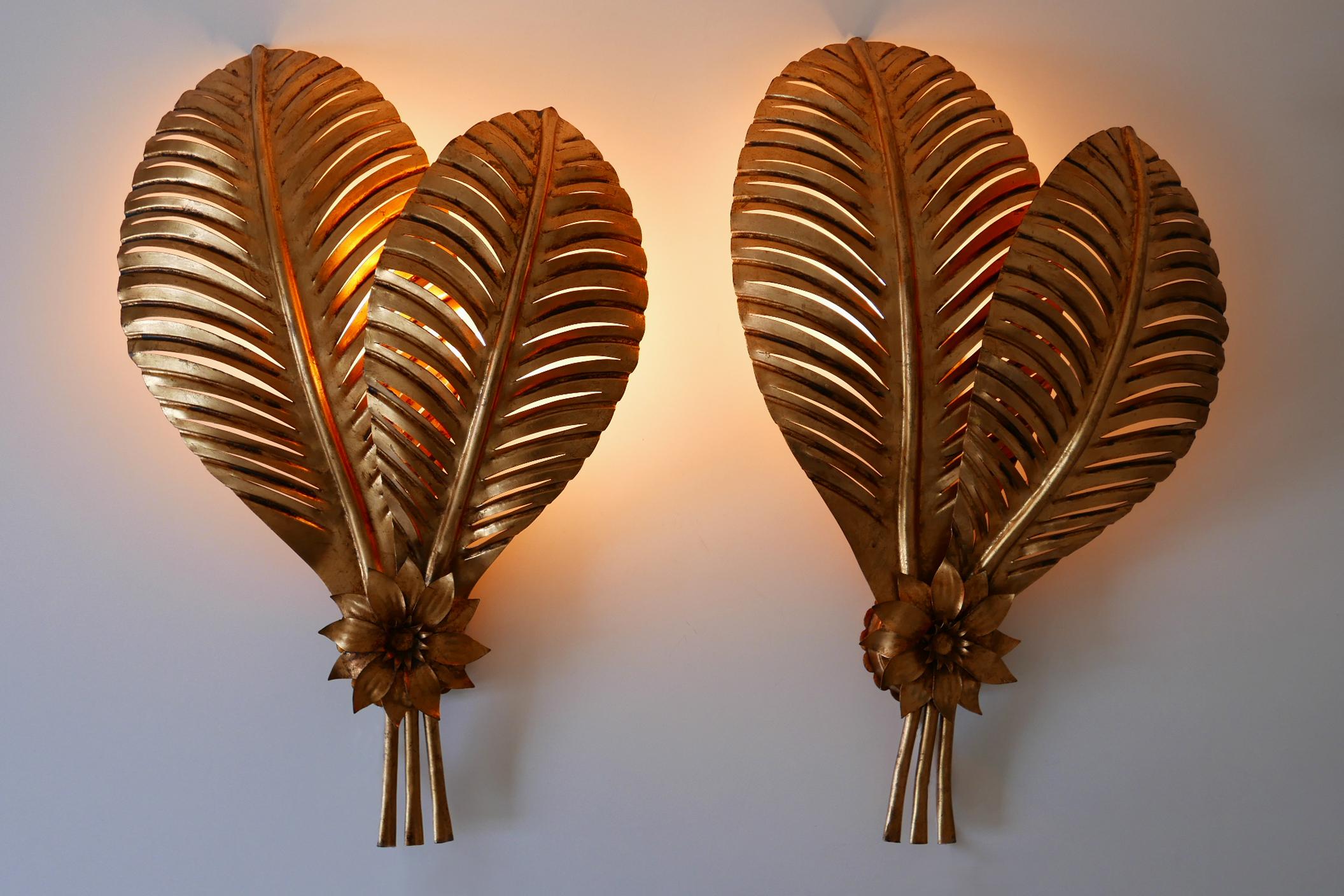 Set of two exceptional and large Mid-Century Modern palm leaf wall lamps or sconces. Designed and manufactured by Hans Kögl, 1970s, Germany.

Executed in gilt and perforated metal sheet and tubes, each lamp comes with 2 x E27 Edison screw fit bulb