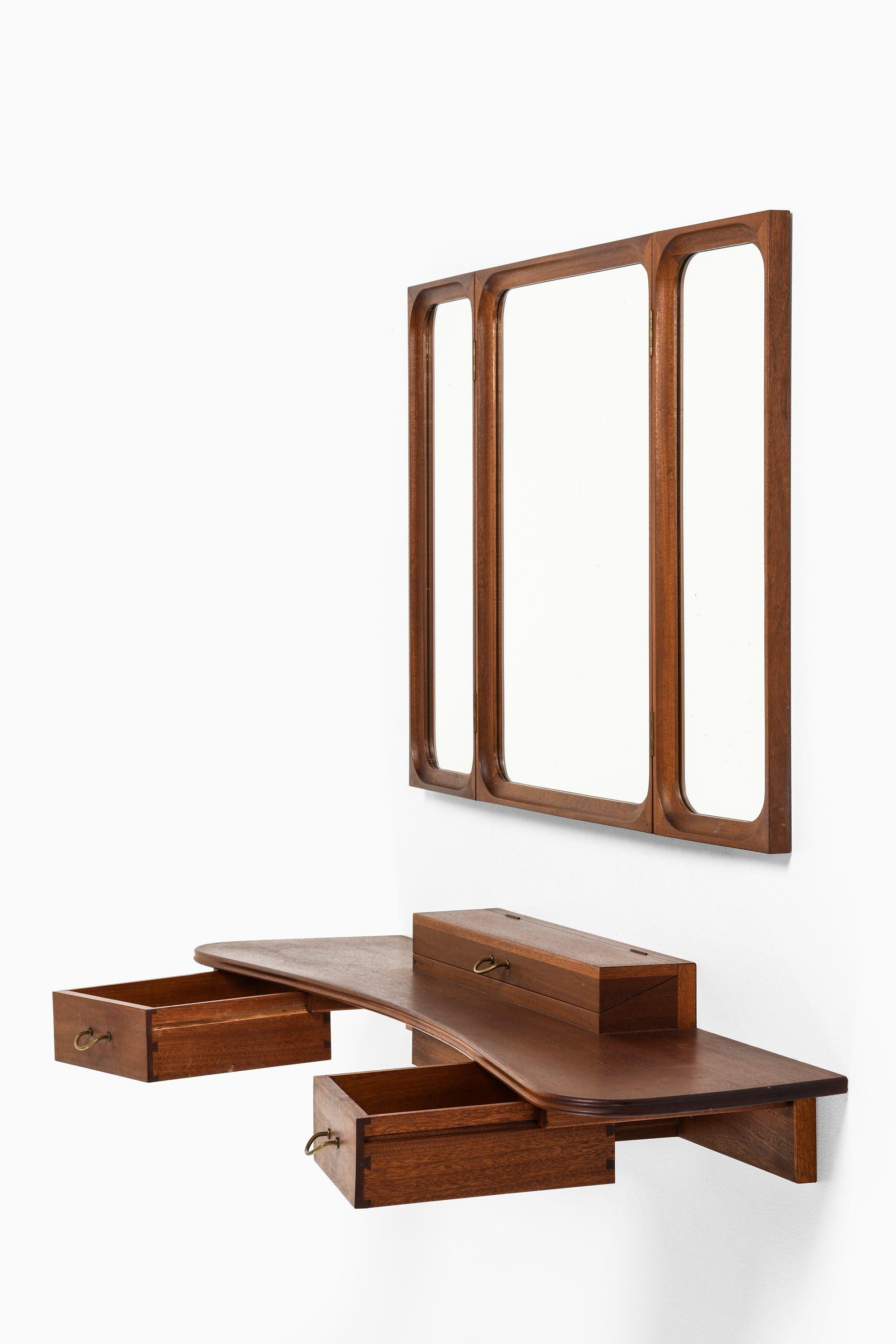 Set of Vanity with Mirror in Mahogany and Brass by Frode Holm, 1950s

Additional Information:
Material: Mahogany, brass
Style: midcentury, Scandinavian
Produced by Illums Bolighus in Denmark
Dimensions (W x D x H): 110 x 29 x 17 cm
Dimensions
