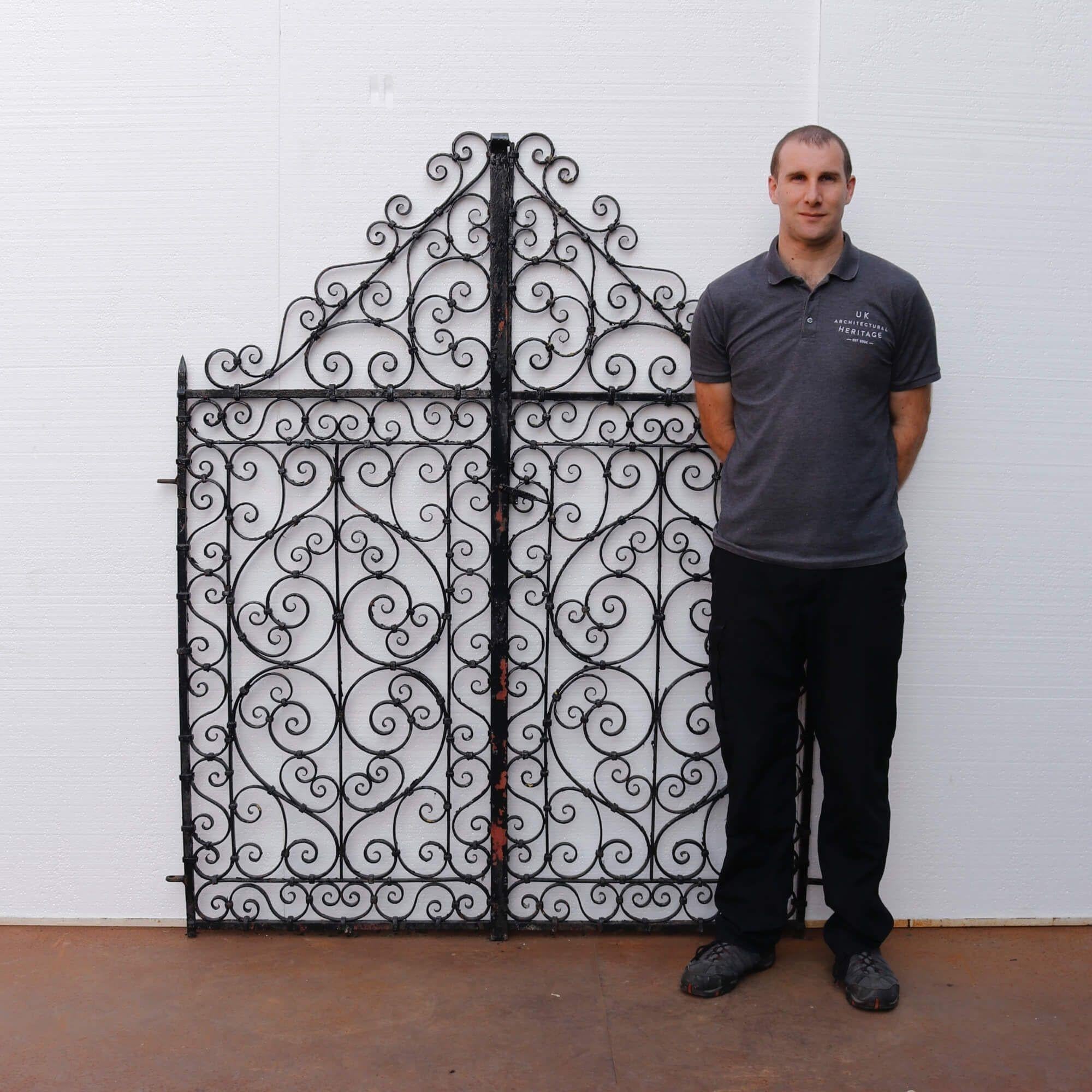 Set of Victorian wrought iron scroll pedestrian gates. The swirling, repeating scroll design and swooping top accompanied by its wide stature would instantly give an eye-catching look to a property. These gates date to 1890, showcasing rich English