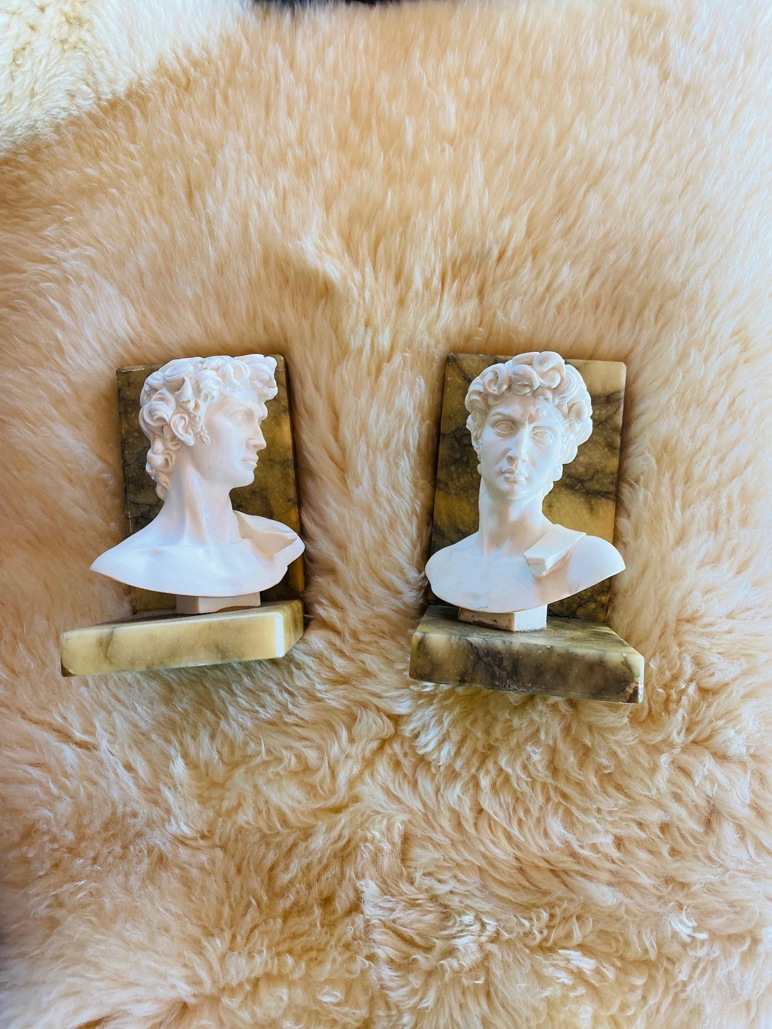 Beautiful and stylist set of alabaster marble bookends with greek busts.  These beautiful pieces date to the 1950s and are incredibly sculptural and impactful.  Resting in alabaster marble bases, the hellenistic style sculpture busts rest while