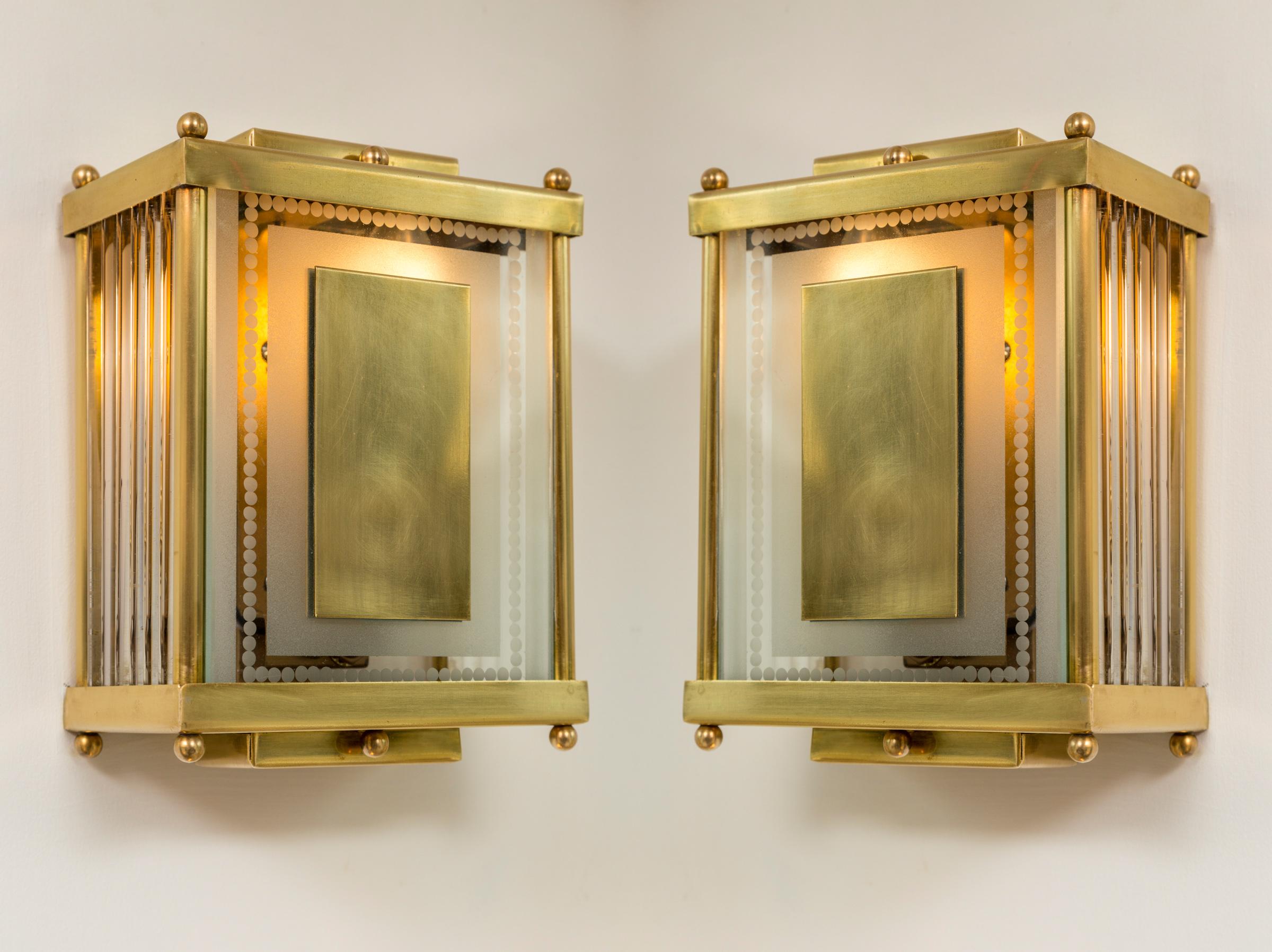 Set of rectangular shaped  brass wall lights with its original etched and frosted  front glass panel and glass rods encasing its sides.  
Illuminated with one candelabra light bulb up to 40 watts incandescent  or higher with use of LED bulb