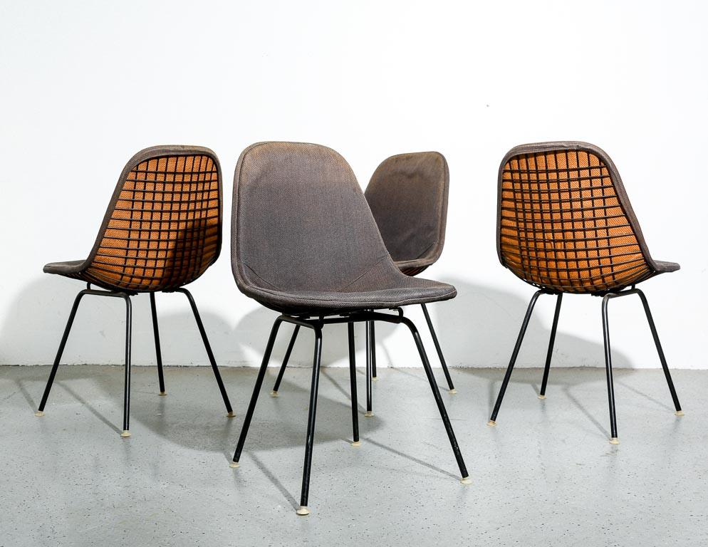 Vieille série de chaises de salle à manger DKX par Charles et Ray Eames pour Herman Miller. Sièges et bases en fil métallique entièrement noirs avec housses de siège d'origine en tissu noir à dos de jute.