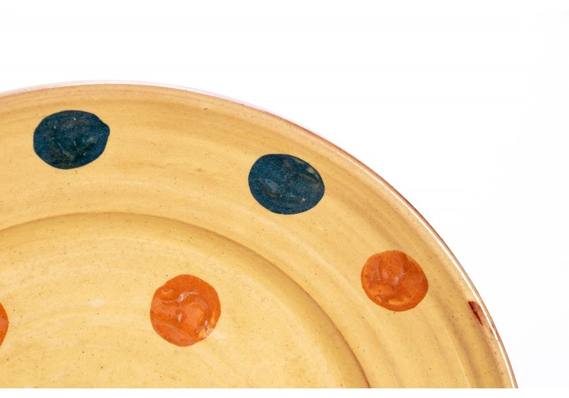 Red terra-cotta pieces glazed in pale tan with a fun polka dot pattern in rust and blue. 
Including: 4 small deep plates, Diameter. 7 1/2