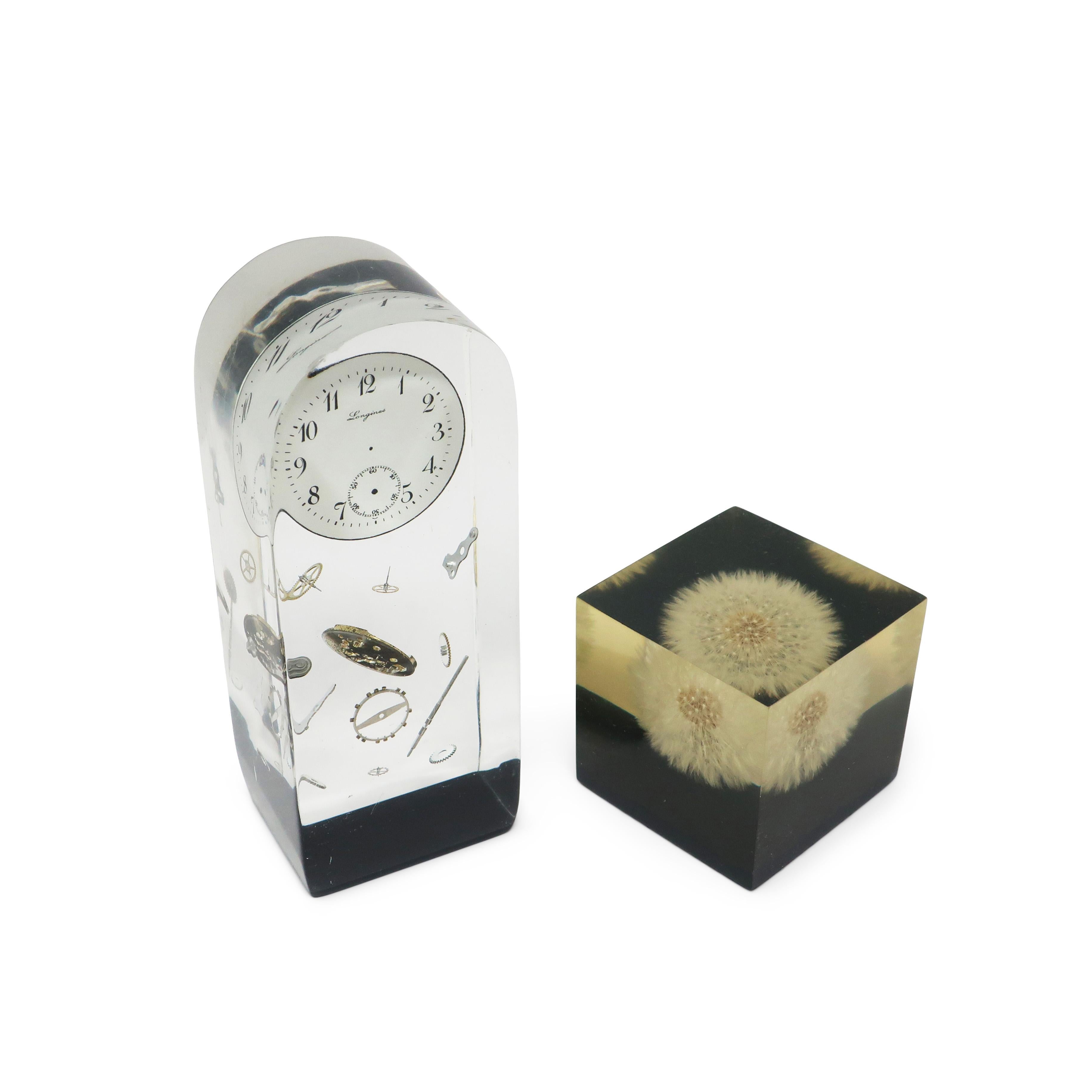 Superbe ensemble de presse-papiers vintage en lucite, datant du milieu du siècle dernier, l'un des 1960 avec un pissenlit et l'autre avec des pièces d'horlogerie.  Magnifiques et attrayants, ils sont parfaits pour décorer une étagère, un bureau ou