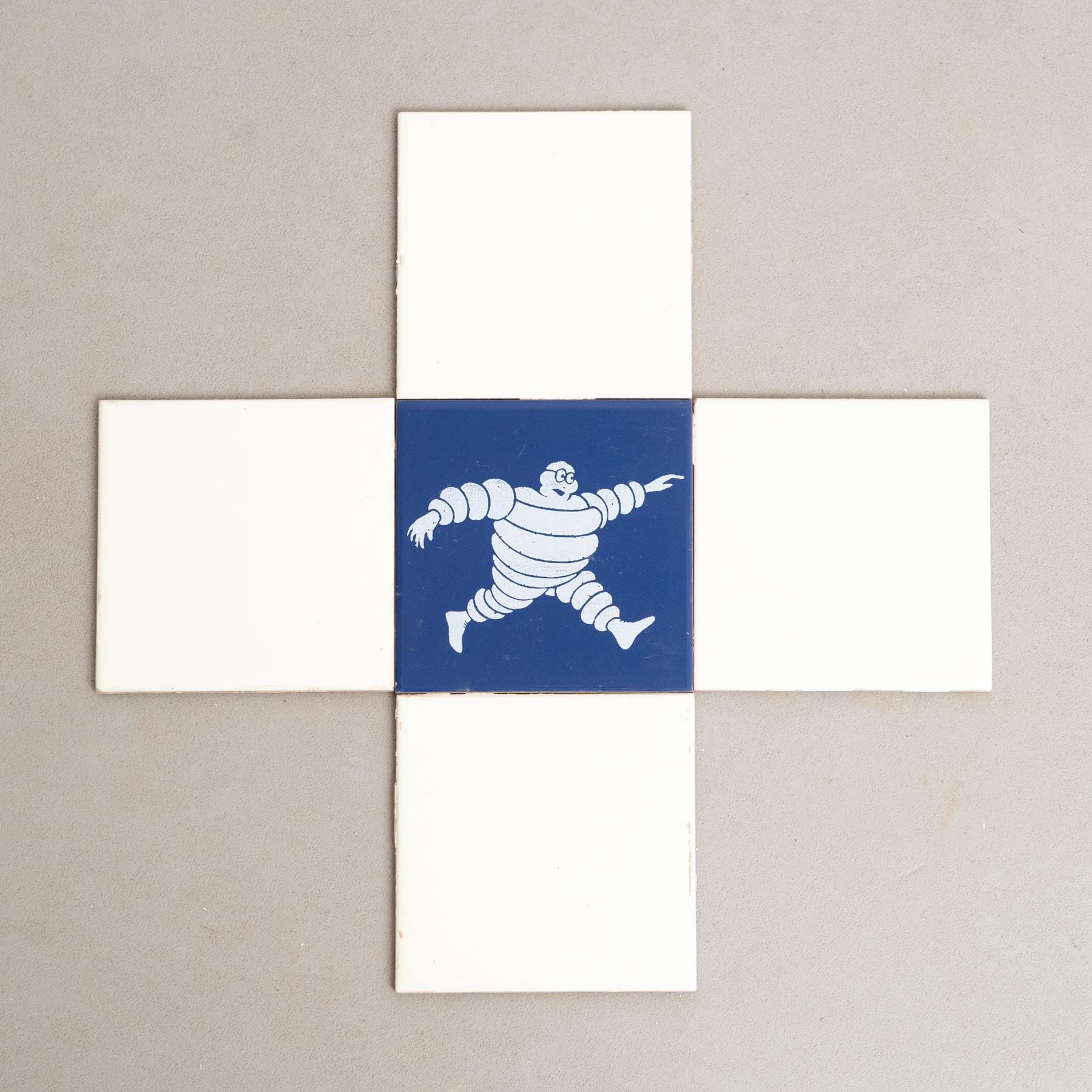 Embarquez pour un voyage au charme vintage avec cet ensemble exceptionnel de carreaux, représentant l'emblématique Bibendum dans un centre bleu vibrant, entouré de carreaux jaunes originaux. Fabriqué par un fabricant inconnu en Espagne vers 1960,