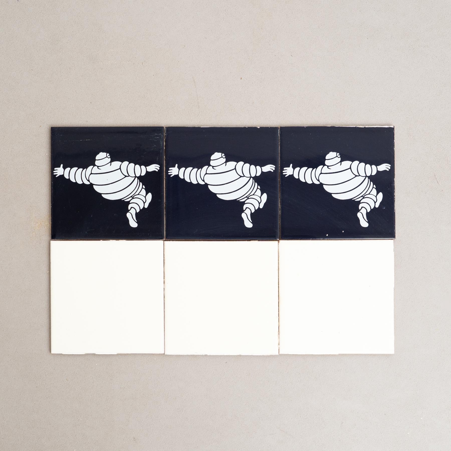 Embarquez pour un voyage au charme vintage avec cet ensemble exceptionnel de carreaux, représentant l'emblématique Bibendum dans un centre bleu vibrant, entouré de carreaux jaunes originaux. Fabriqué par un fabricant inconnu en Espagne vers 1960,