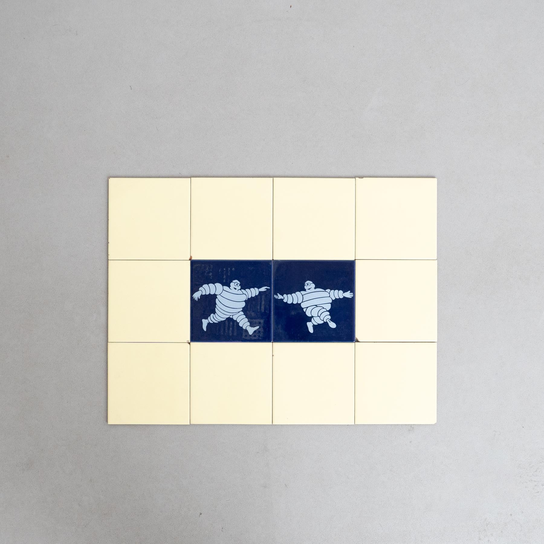 Embarquez pour un voyage au charme vintage avec cet ensemble exceptionnel de carreaux, représentant l'emblématique Bibendum dans un centre bleu vibrant, entouré de carreaux jaunes originaux. Fabriqué par un fabricant inconnu en Espagne vers 1960,