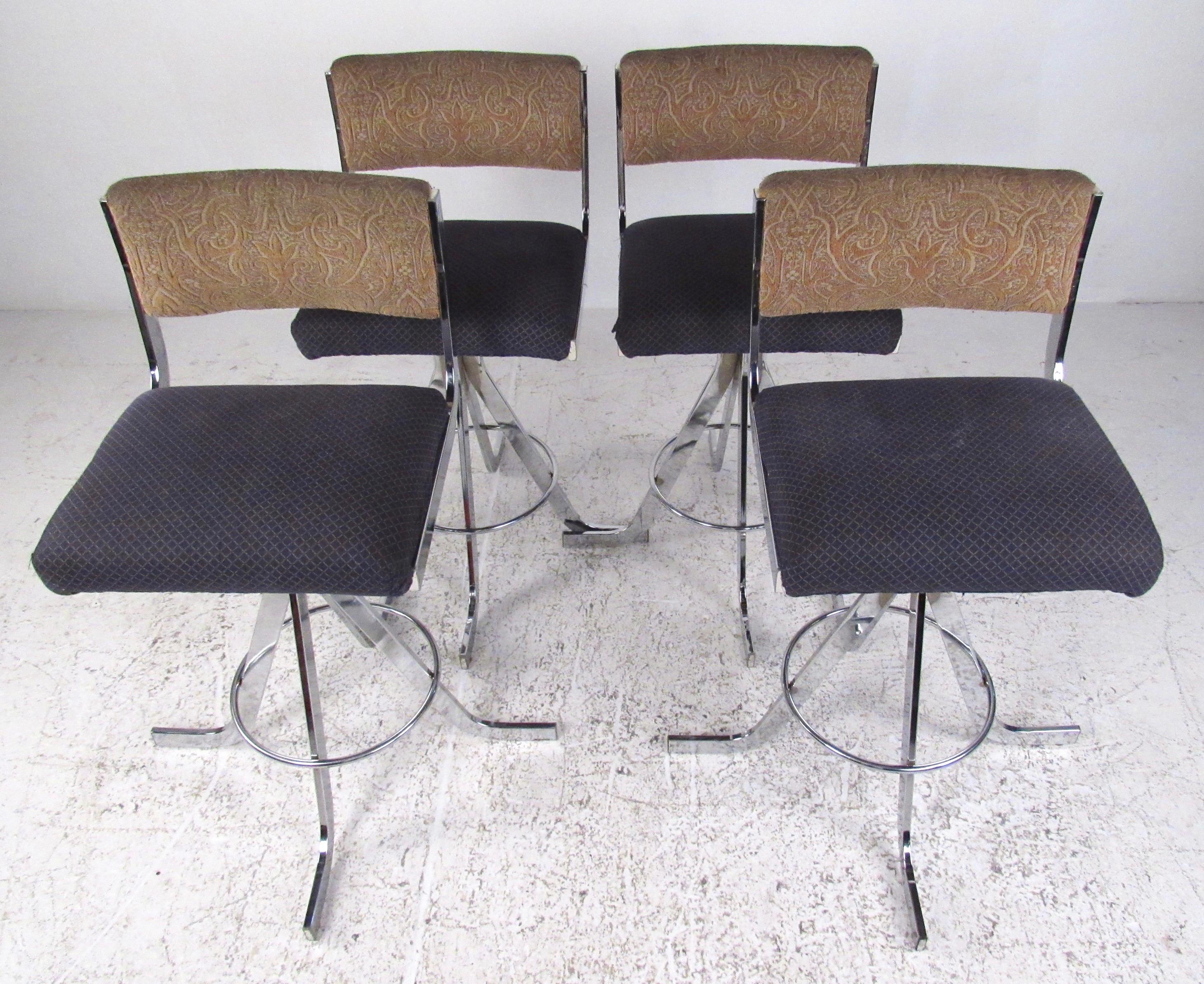 This set of four modern chrome swivel stools feature upholstered seats and seat backs and striking mid-century style frames. With swivel seats and sturdy chrome construction this unique pair of 26 inch seat height stools add to any bar or counter