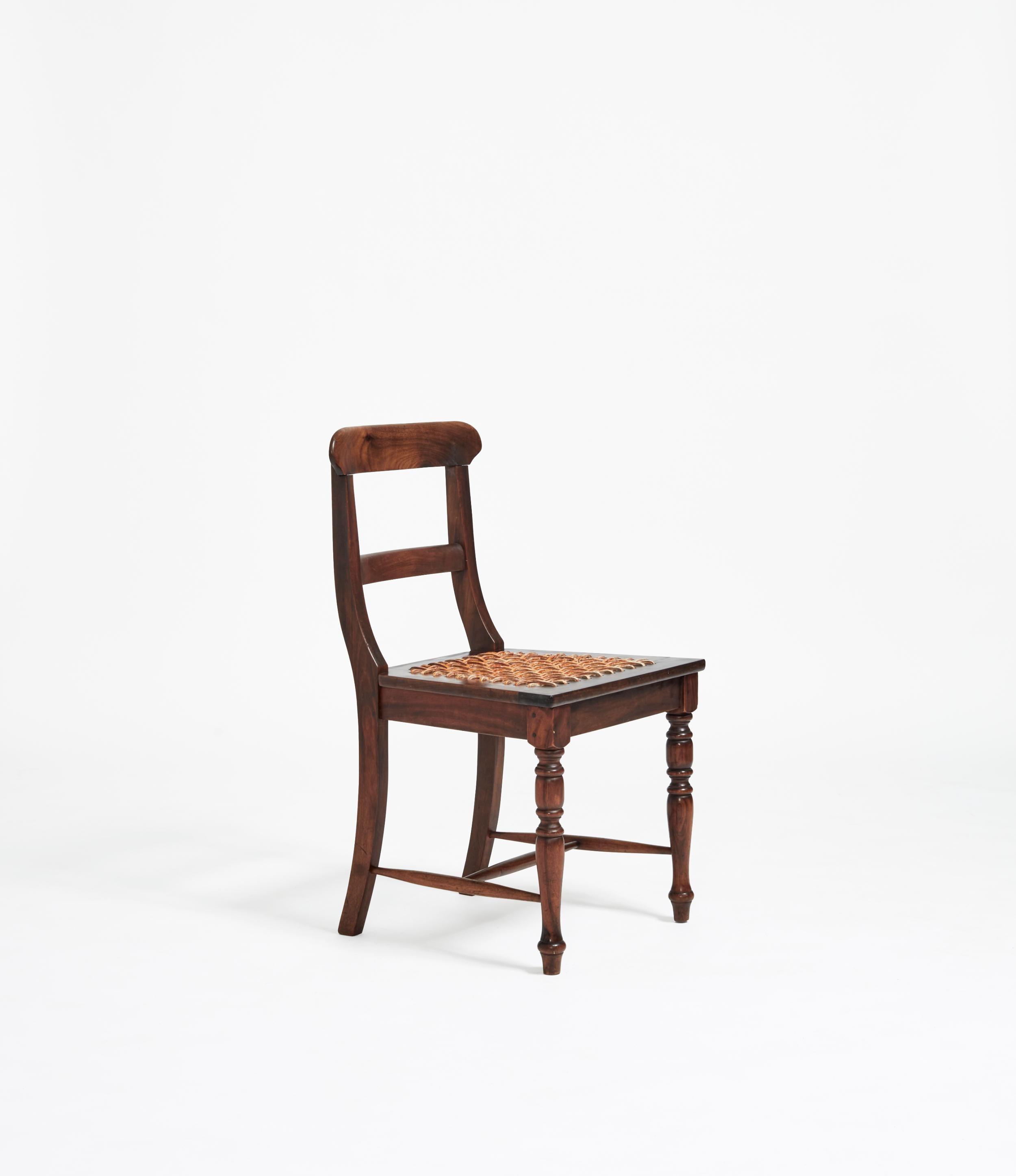 The “riempies” is a settler Dutch reference to leather thongs that are seen to be latticed as the seating for this chair. Threading the “riempies” through holes alongside the seat allow for it to be weaved with structural integrity; minimising