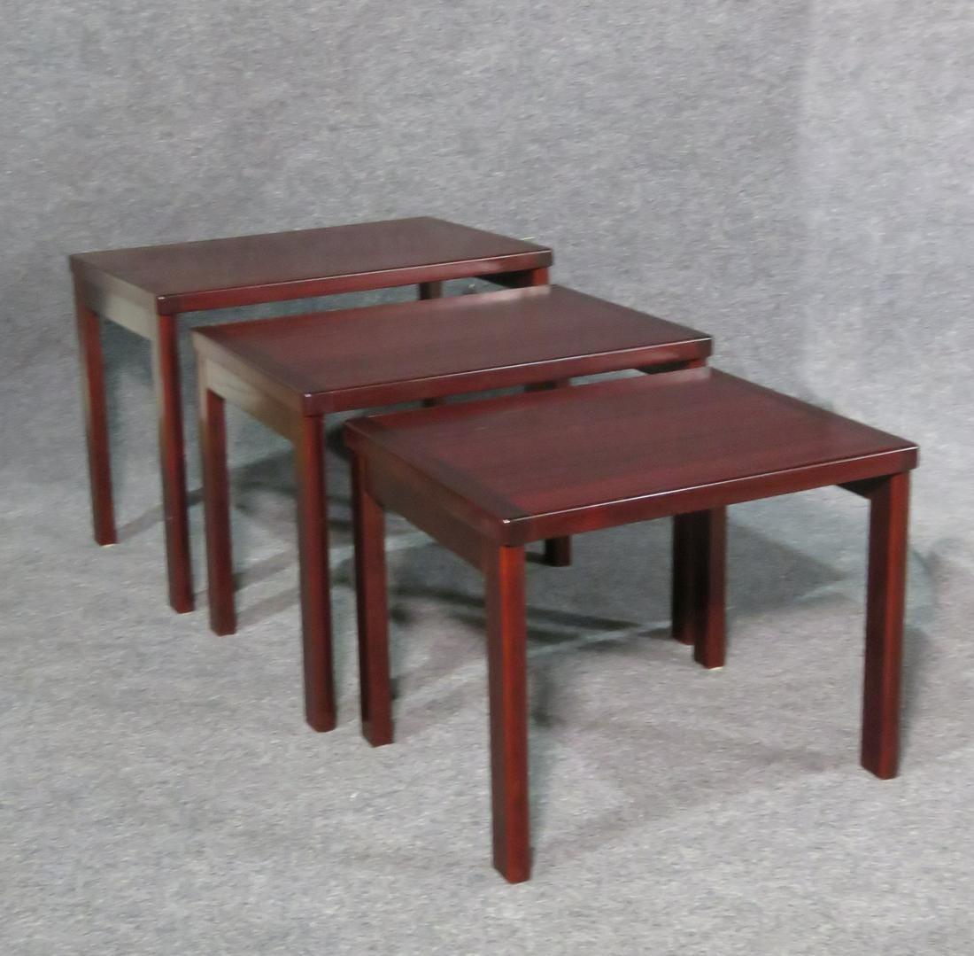 Showing off a deep shade of red rosewood grain, this vintage set of nesting tables is unique and full of Mid-Century Modern style. Please confirm item location with seller (NY/NJ).