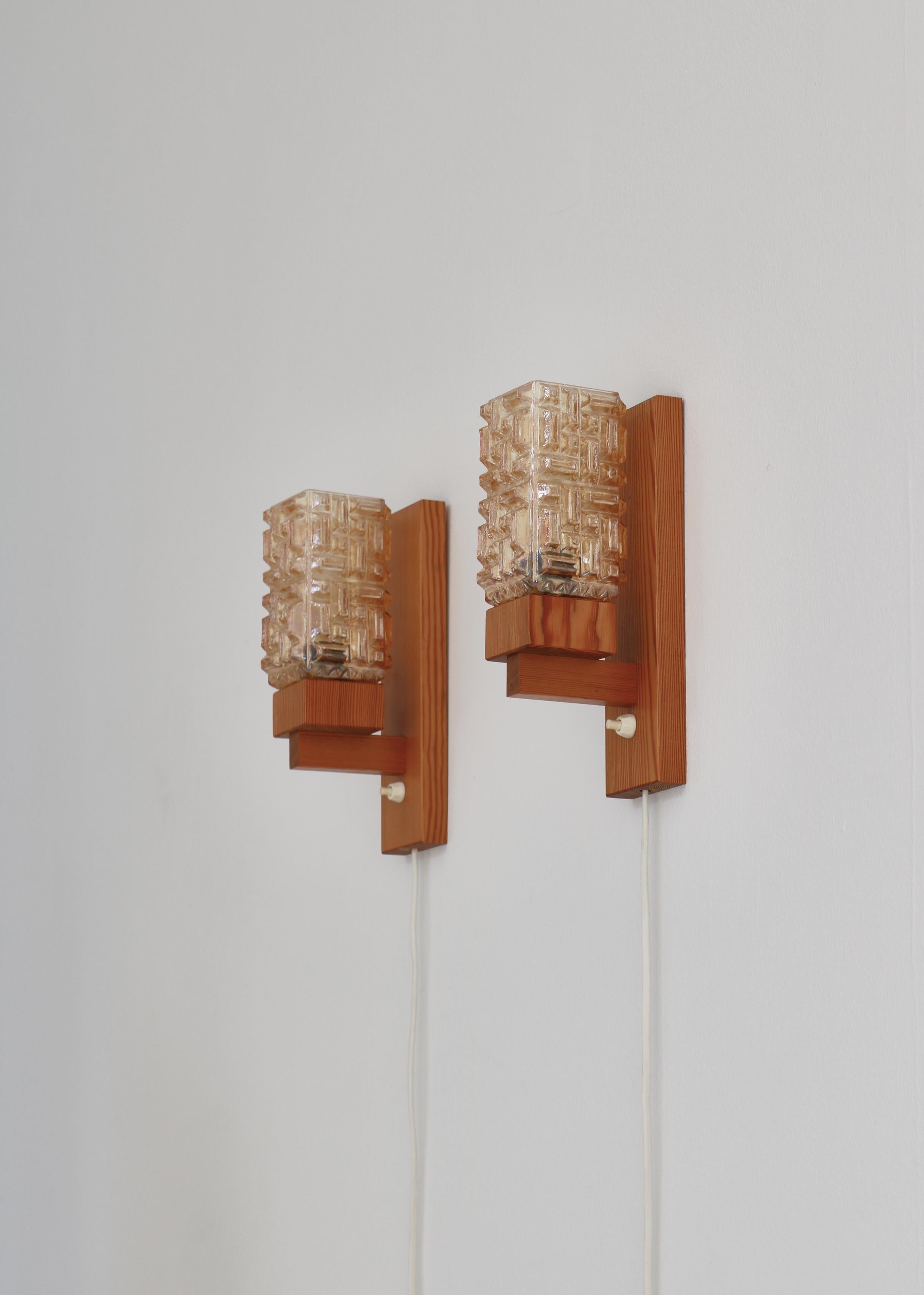 Wonderful set of Danish Modern wall lamps in solid Scandinavian pinewood and amber colored glass shades. The lamps were made in the 1970s by the small Danish workshop 