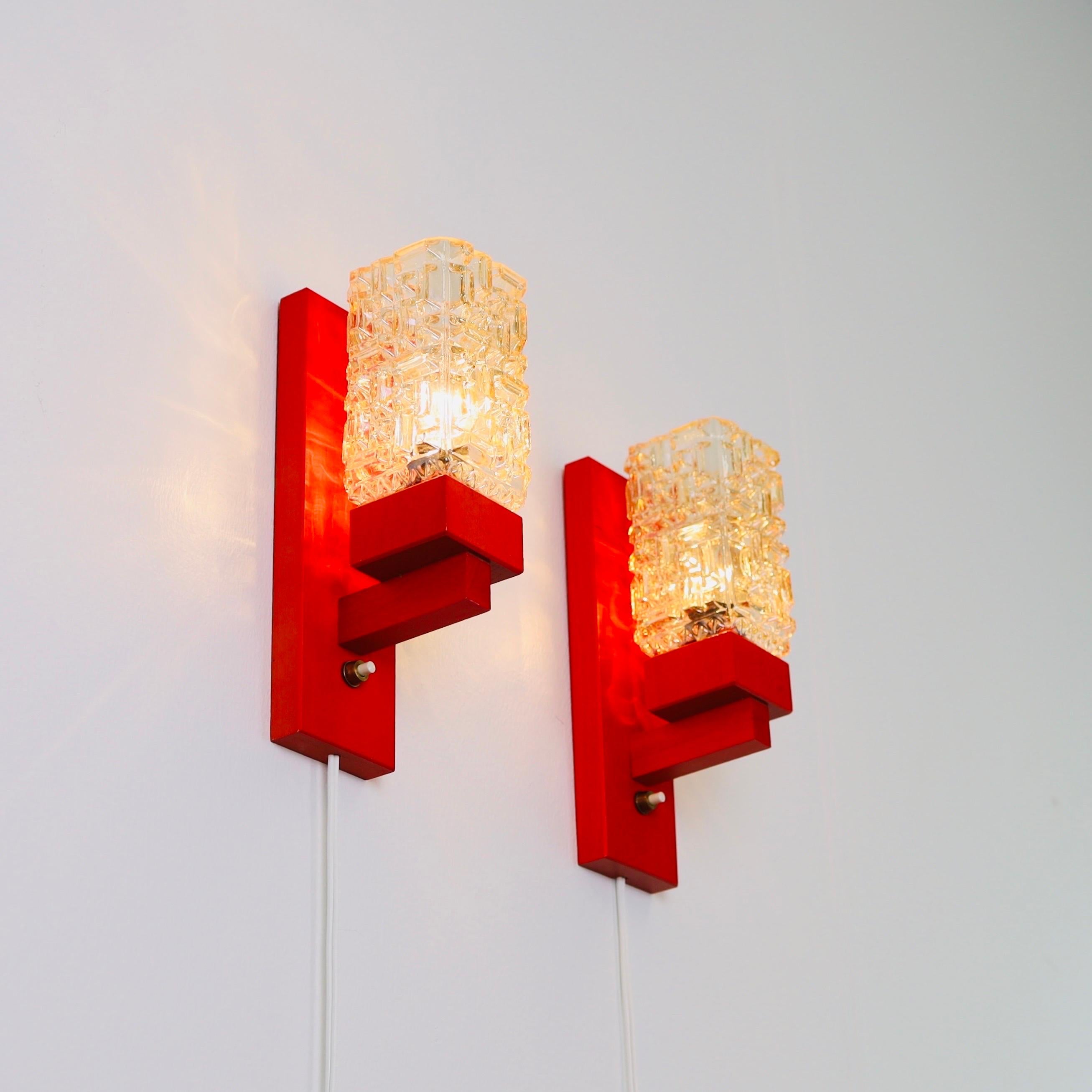Exquisite set of Danish Modern wall lamps in Red stained Scandinavian beech wood and amber colored glass shades. The sconces were made in the 1970s by the Danish workshop 'Vitrika'. 

* A set (2) red stained wood wall lamps with amber glass shades
*