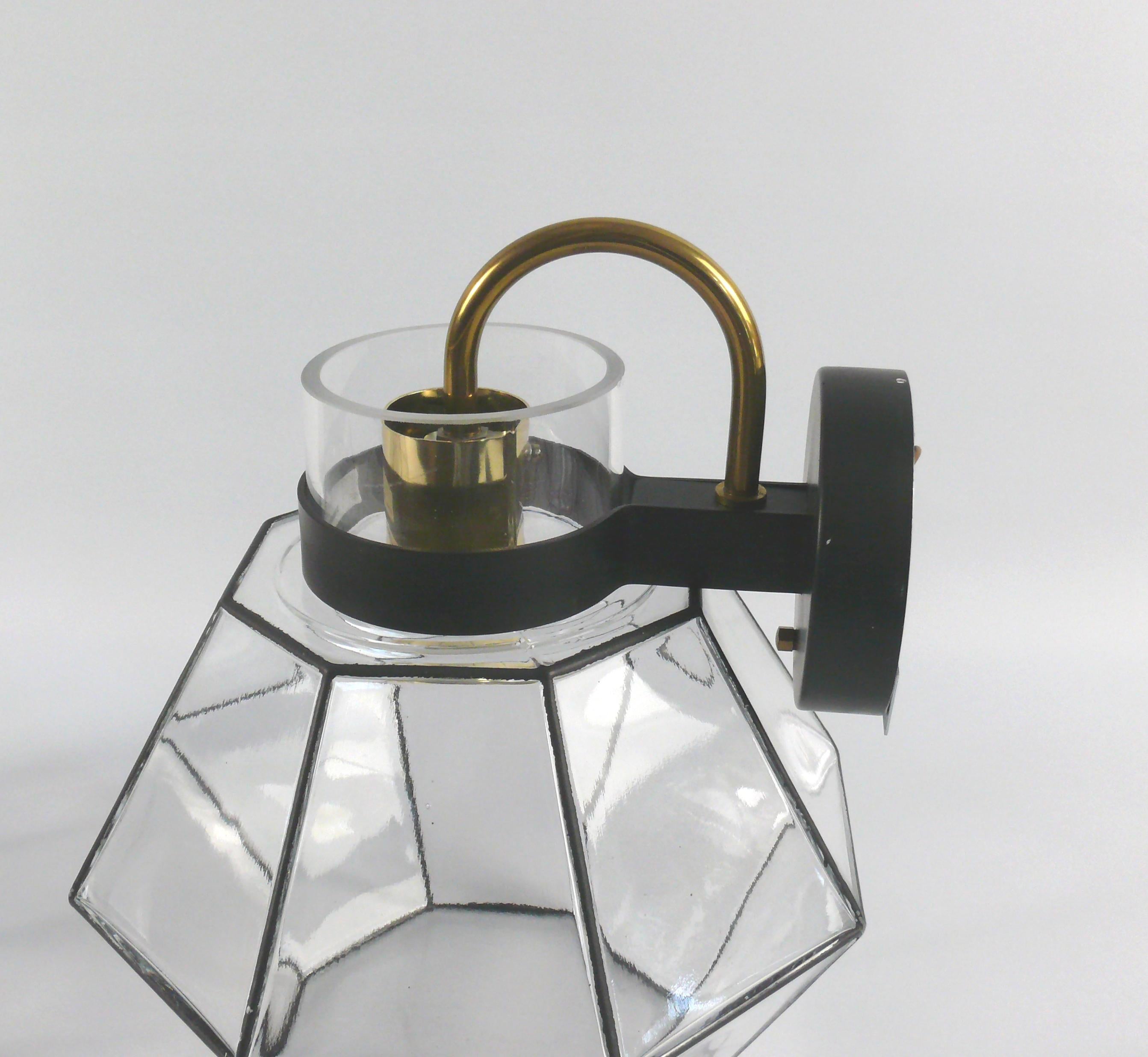 Set of wall lights by the company Glashütte Limburg from the period 1970-1979. The lights are characterized by a high quality of manufacture and a minimalist design. The octagonal glass is visually divided into individual panes. The bracket is made