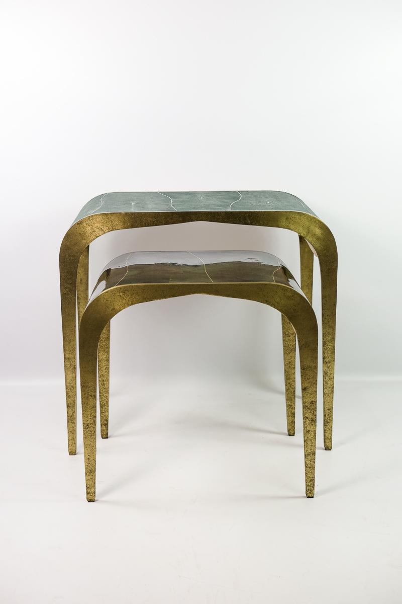 The nesting tables FLUCTUS have a waterfall shape and they are made of a mix of natural materials.
The large table has a nice green shagreen top and the small table has a green polished shell marquetry top.
Both tables have brass trims on top and a