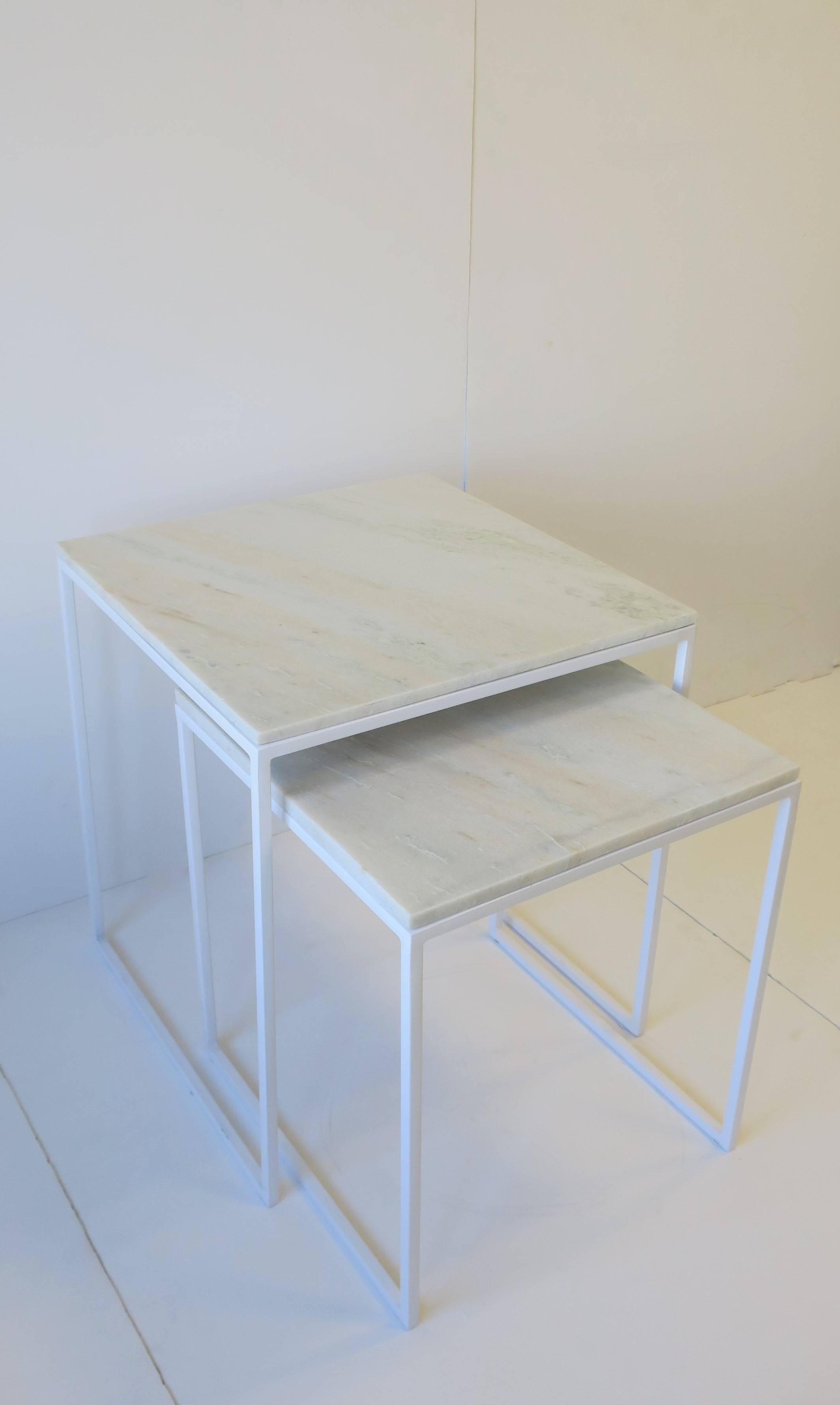 Un ensemble/paire de tables gigognes ou de tables d'appoint en marbre blanc granité de style moderne ou minimaliste. Le marbre granit est blanc avec de légères traces de gris et de tons chair, comme le montrent les images. La base est un blanc