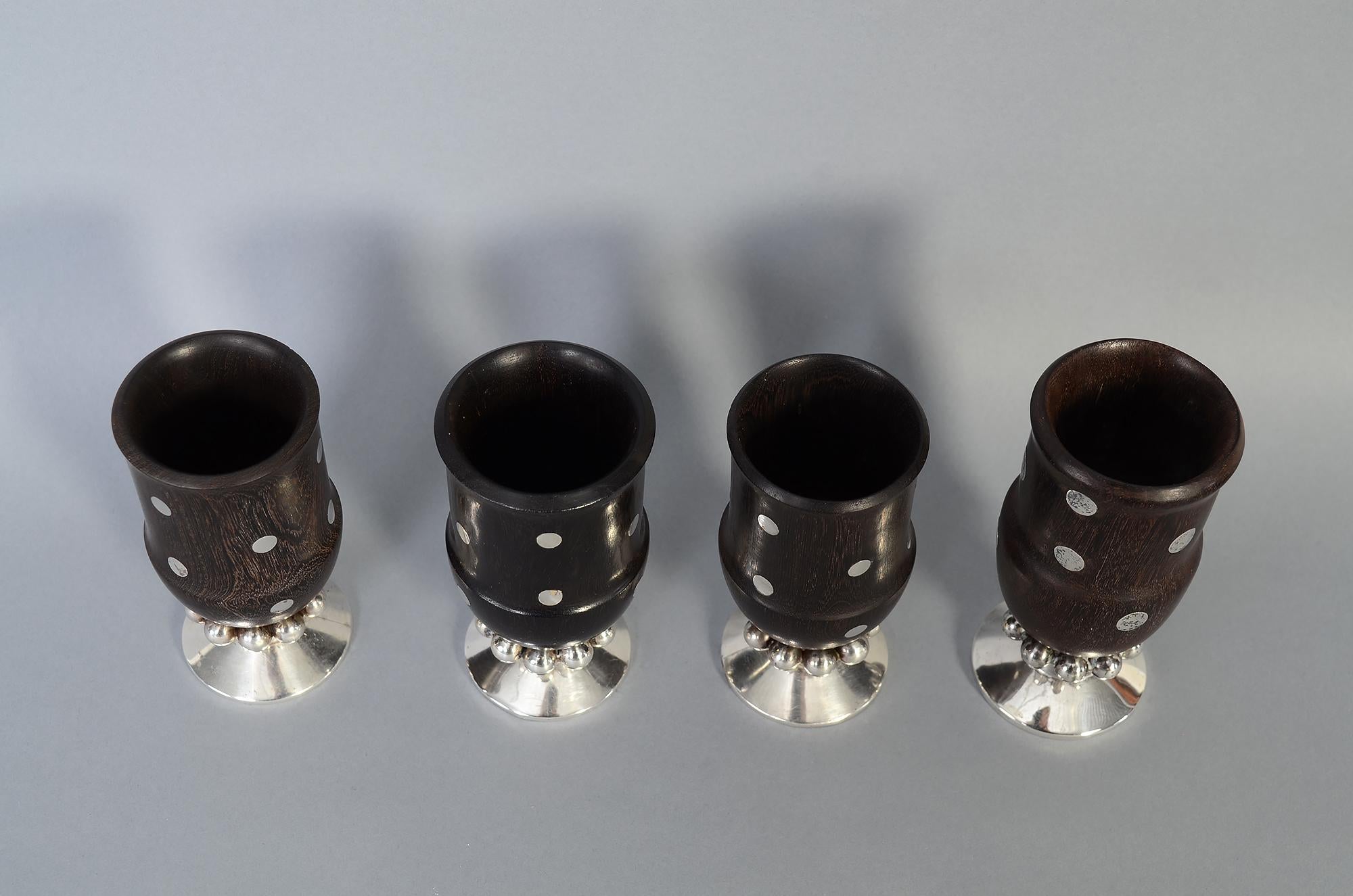 Beautiful assembled set of four ebony goblets with sterling dots by silver master, William Spratling. Three dimensional silver balls circle the stem of the goblets. Three of the goblets measure 4 1/2 inches tall. The fourth one is 4 13/16