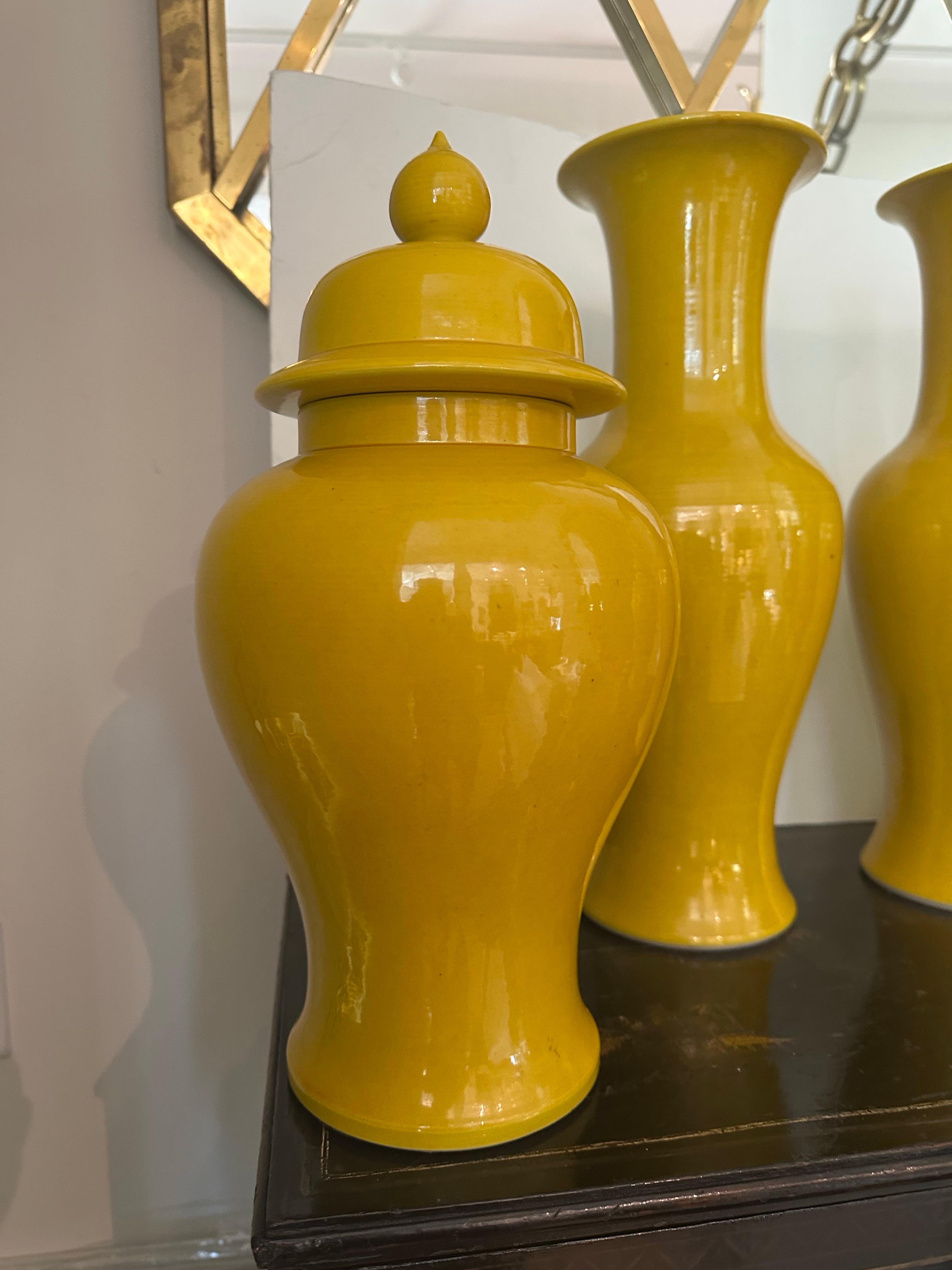 Two pairs of saffron yellow Japanese ceramic vases and ginger jars with lids...