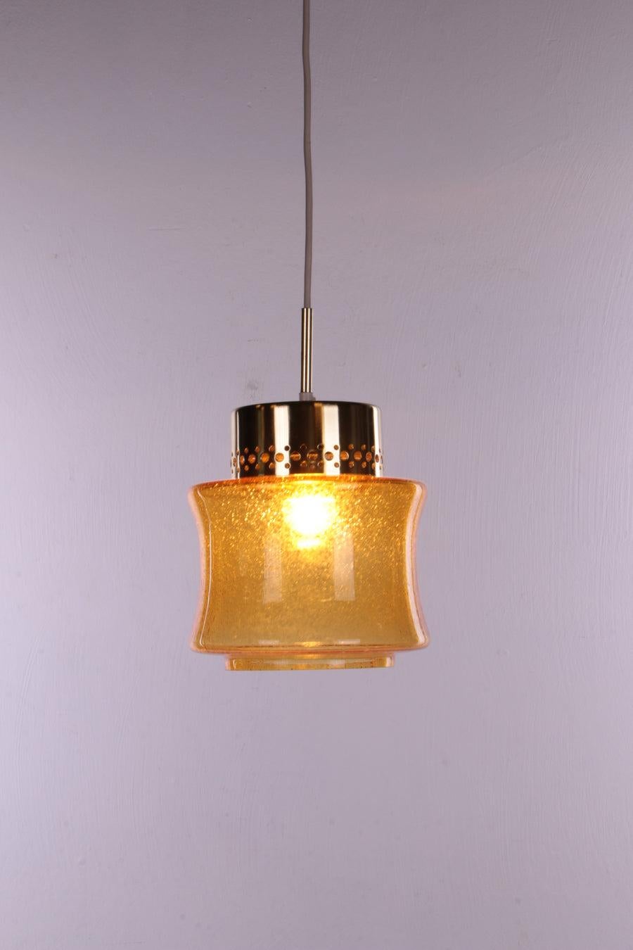 A set off 3 pice Vintage Hollywood Regency Pendant Lamp, 1960s Germany

These are very beautiful lamps with a beautiful yellow colored glass shade.

Mounted in a gold-colored holder with an E27 fitting.

These lamps were made by VEB narva