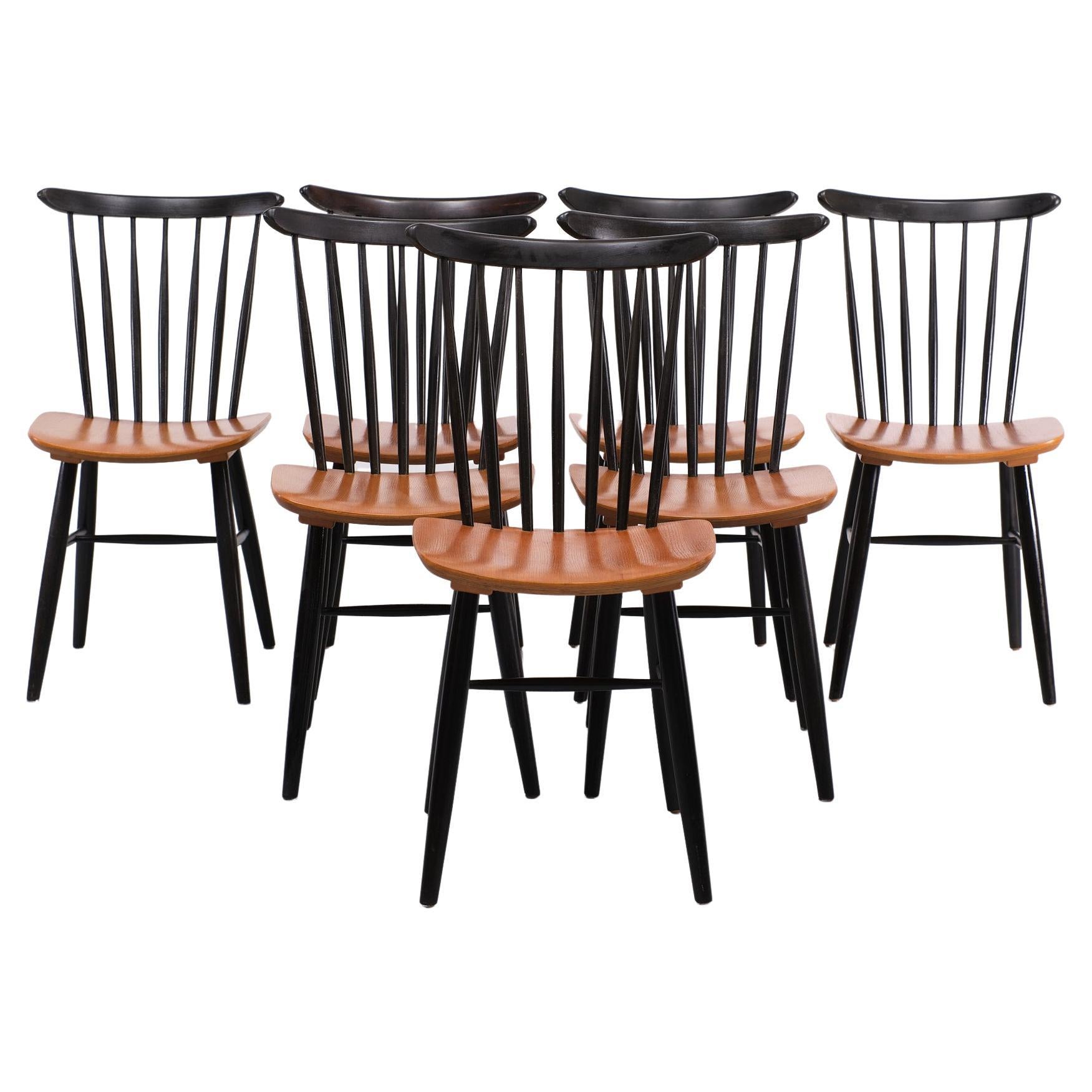 Beautiful set off 7 dining chairs designed in the 1960s. The chairs were made of black painted wood, the seat of plywood veneered with teak. The chairs are in a very good condition.