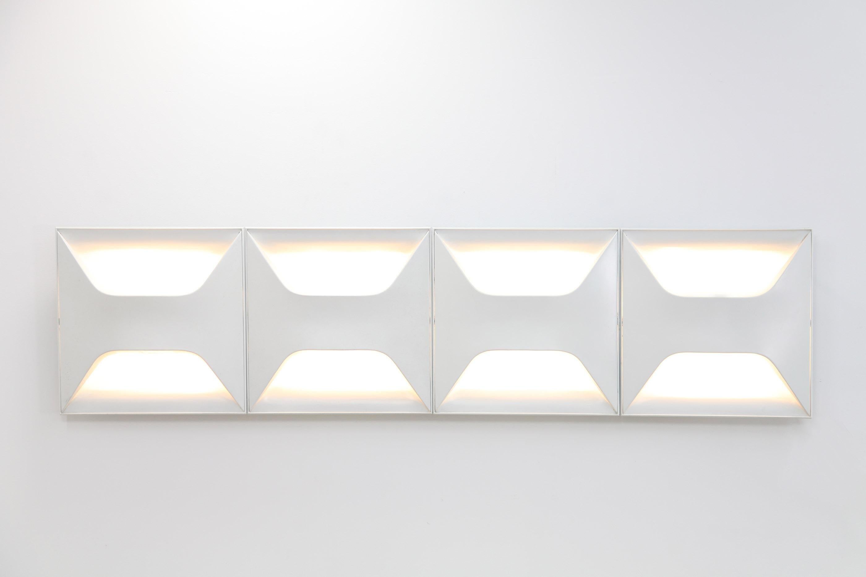 Set of four white lacquered light scounces by Staff. These are four individual pieces, measuring 62,5 x 62,5 cm each and they can be arranged differently. Each lamp features four light bulbs.