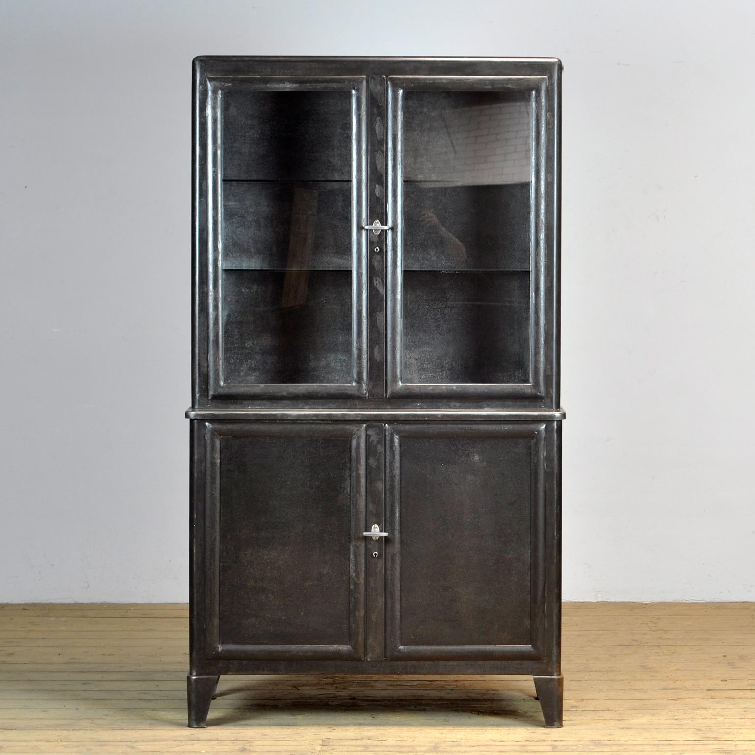 Set of medical cabinets produced by Brüder Fuchs, Germany in the 1930s. The cabinets have been stripped to the metal and treated against rust. At the top a display case with two glass shelves. In the lower part it is possible to make two more