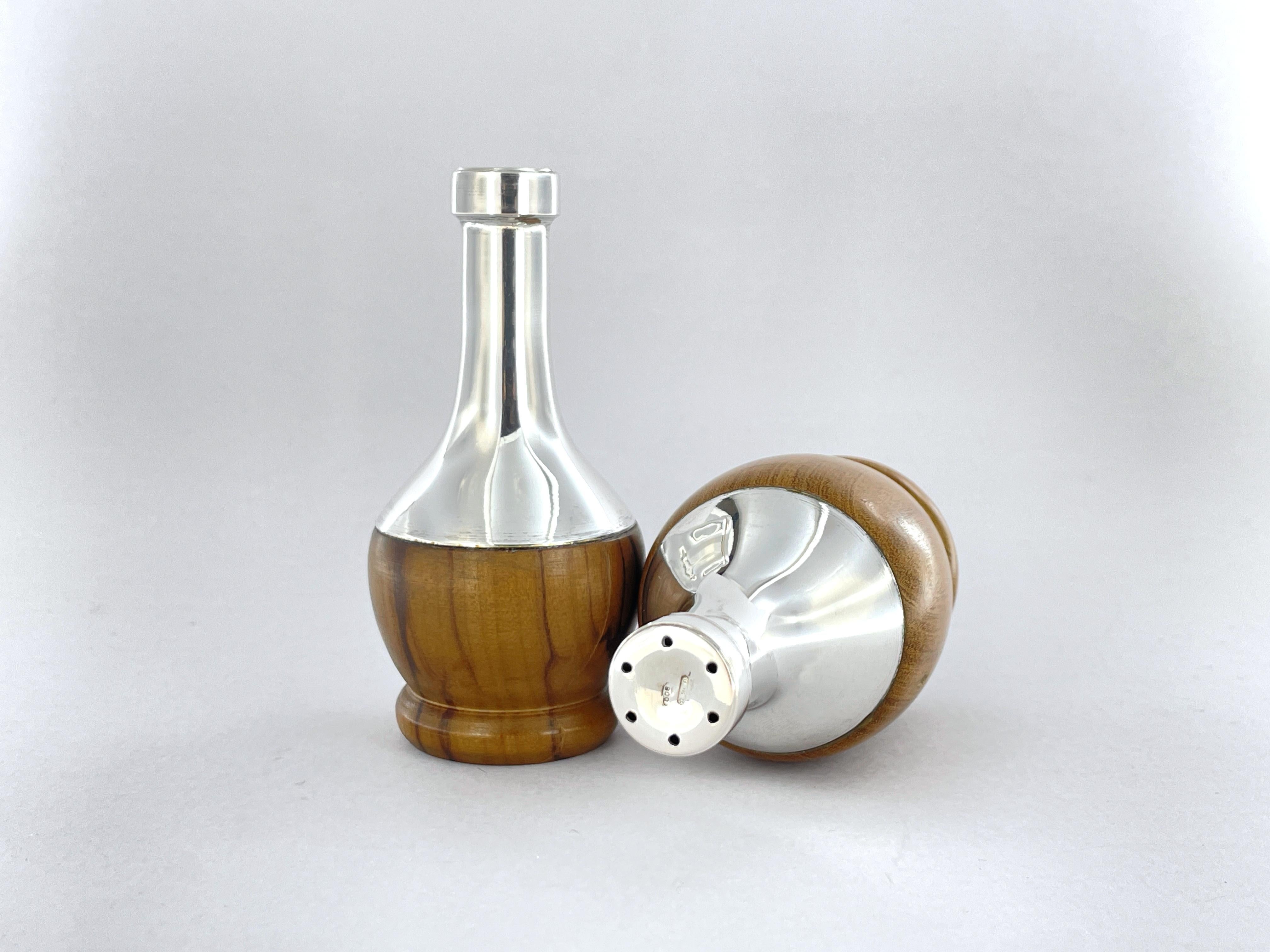 Salt Pepper set and small snack container made of olive wood and 800 silver.
Set consisting of 3 pieces.
Total weight 195 g
Size:
Salt rack height mm 95
Pepper holder height mm 90
Snack holder apple height 135 mm, diameter 80 mm

Miniature