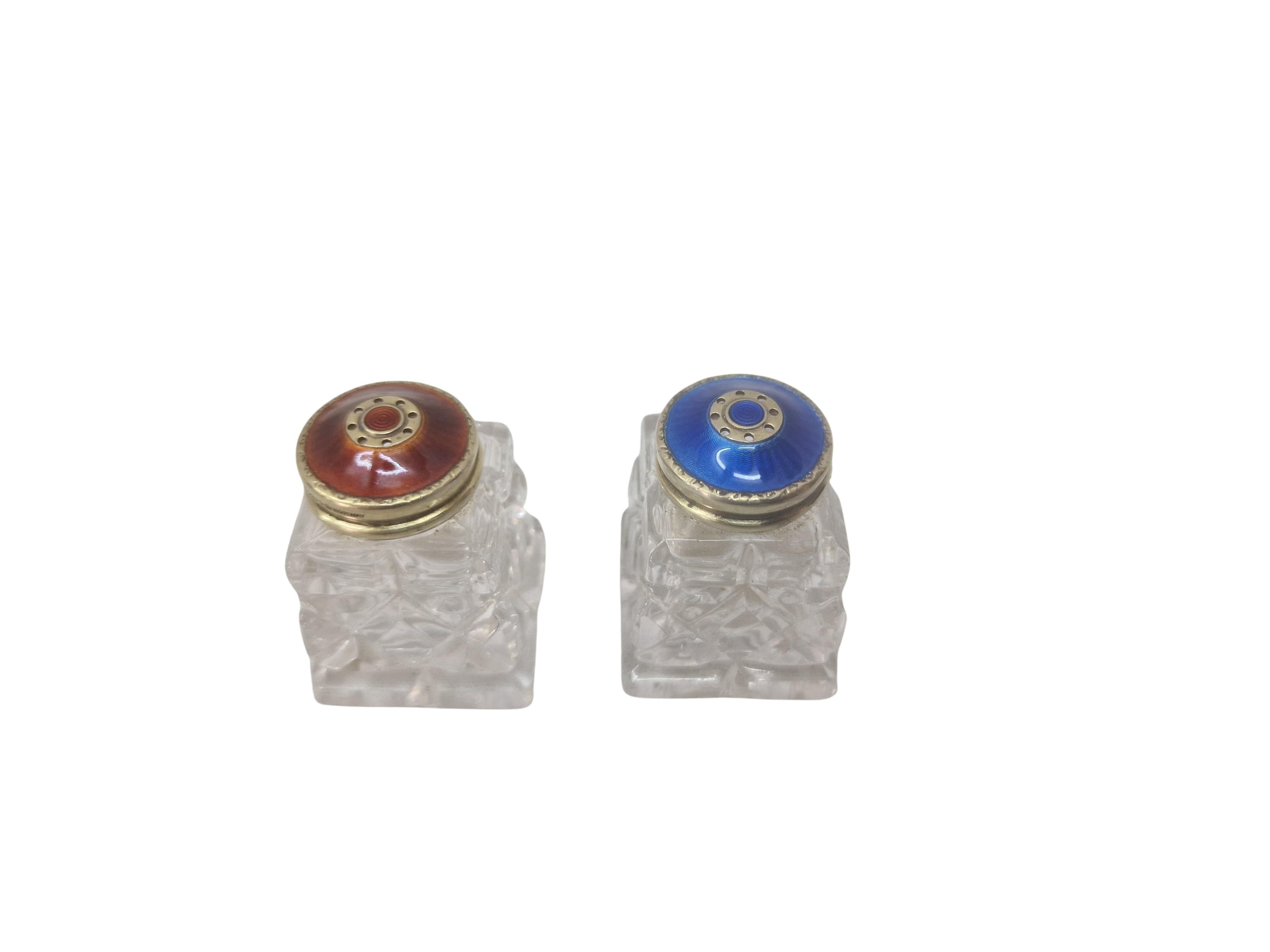 Beautiful set of a salt and a pepper shaker, with guilloche enamel, made in the 1920s to 30s in Oslo, Norway (hallmarked).

The two-tone design of this set is exceptional. The shakers are made of crystal glass, which has been ground in a special,