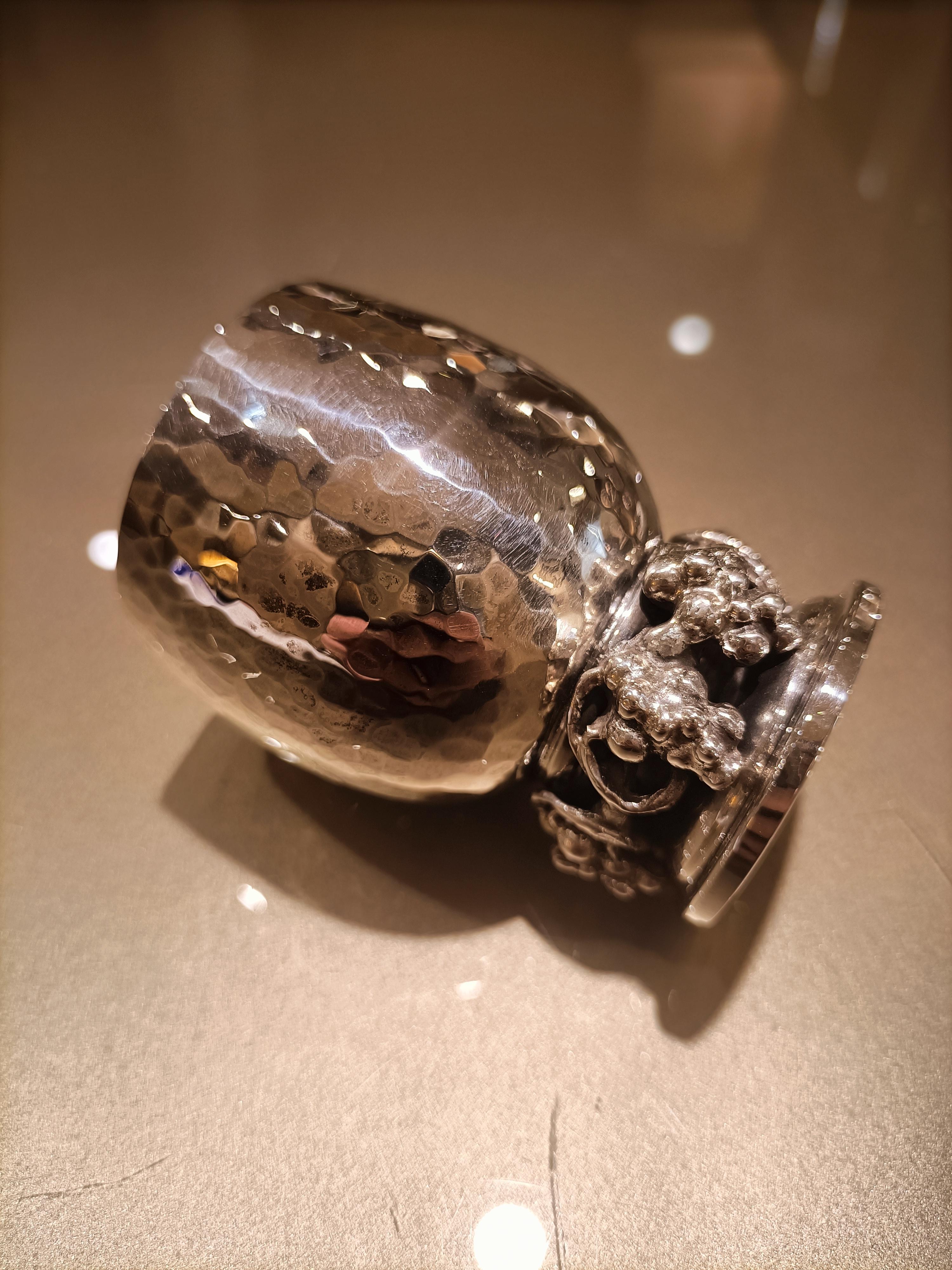 Set of six solid silver liquor glasses, made by Italian manufacture. Each shot glass has a vermeil interior and an entirely hand-hammered exterior and a base decorated with bunches of grapes.