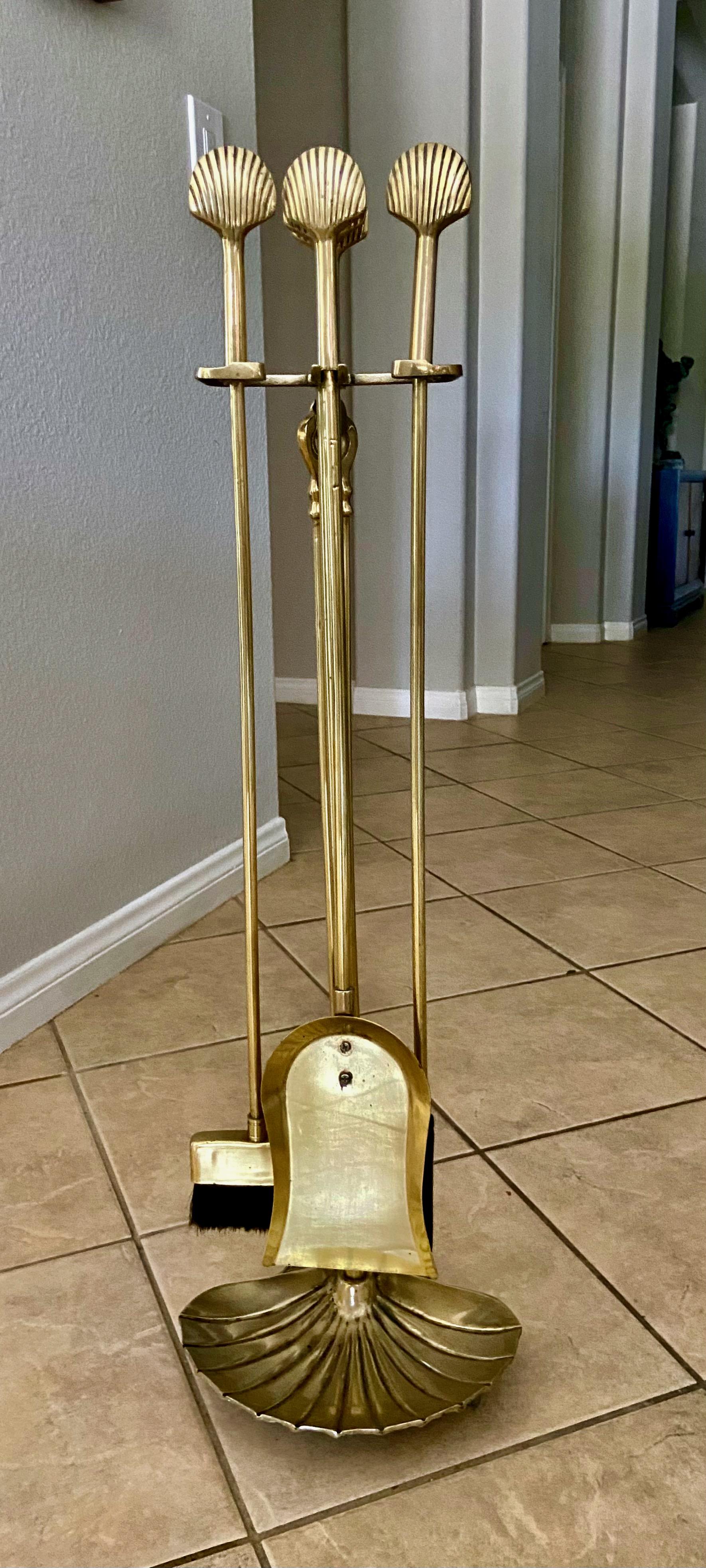 A midcentury set of Seashell or Clam motif brass fireplace tools set, with shell shape brass tool handles and larger clam shape stand.