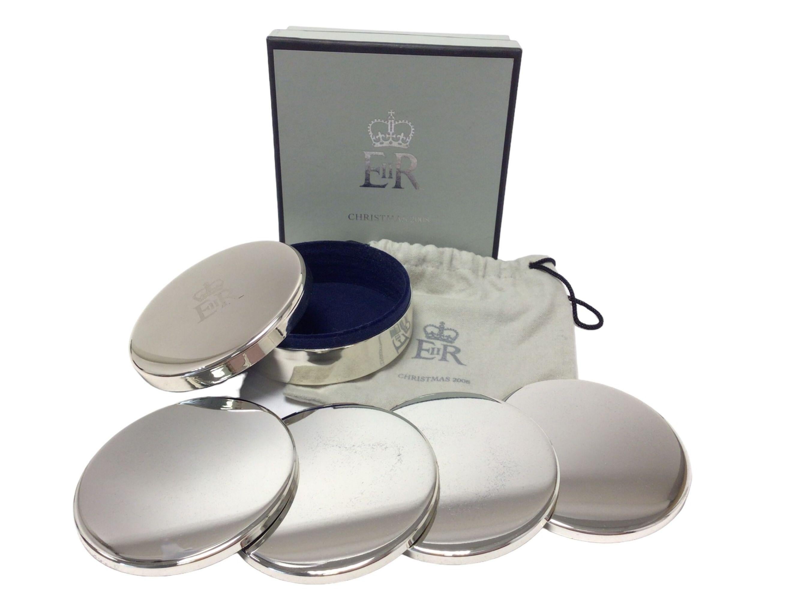 set 4 posavasos plateados Reina Isabel II Casa Real 2008 Regalo de Navidad, 
H.M. Regalo de Navidad 2008 de la Casa Real de la Reina Isabel II, Juego de 4 posavasos plateados  dentro de una caja plateada con la cifra de la Corona Real, junto con una