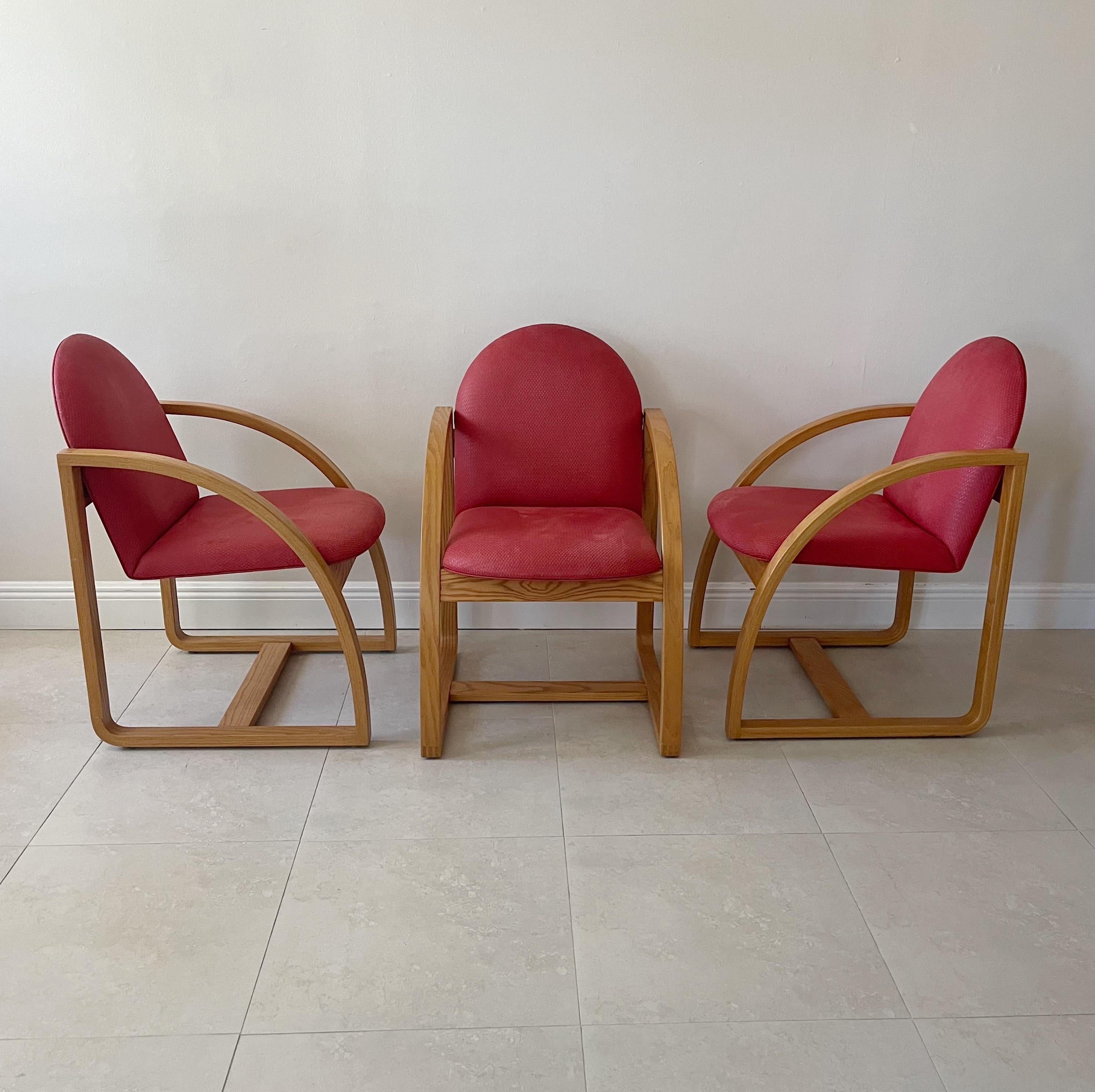 Set of six wood dining chairs with original red upholstery by Peter Danko, born Washington DC 1949. Peter designed the Clyde’s chairs for Clyde’s Restaurant, Tysons Corner VA. This was his first large commission for multiples. Awarded a National