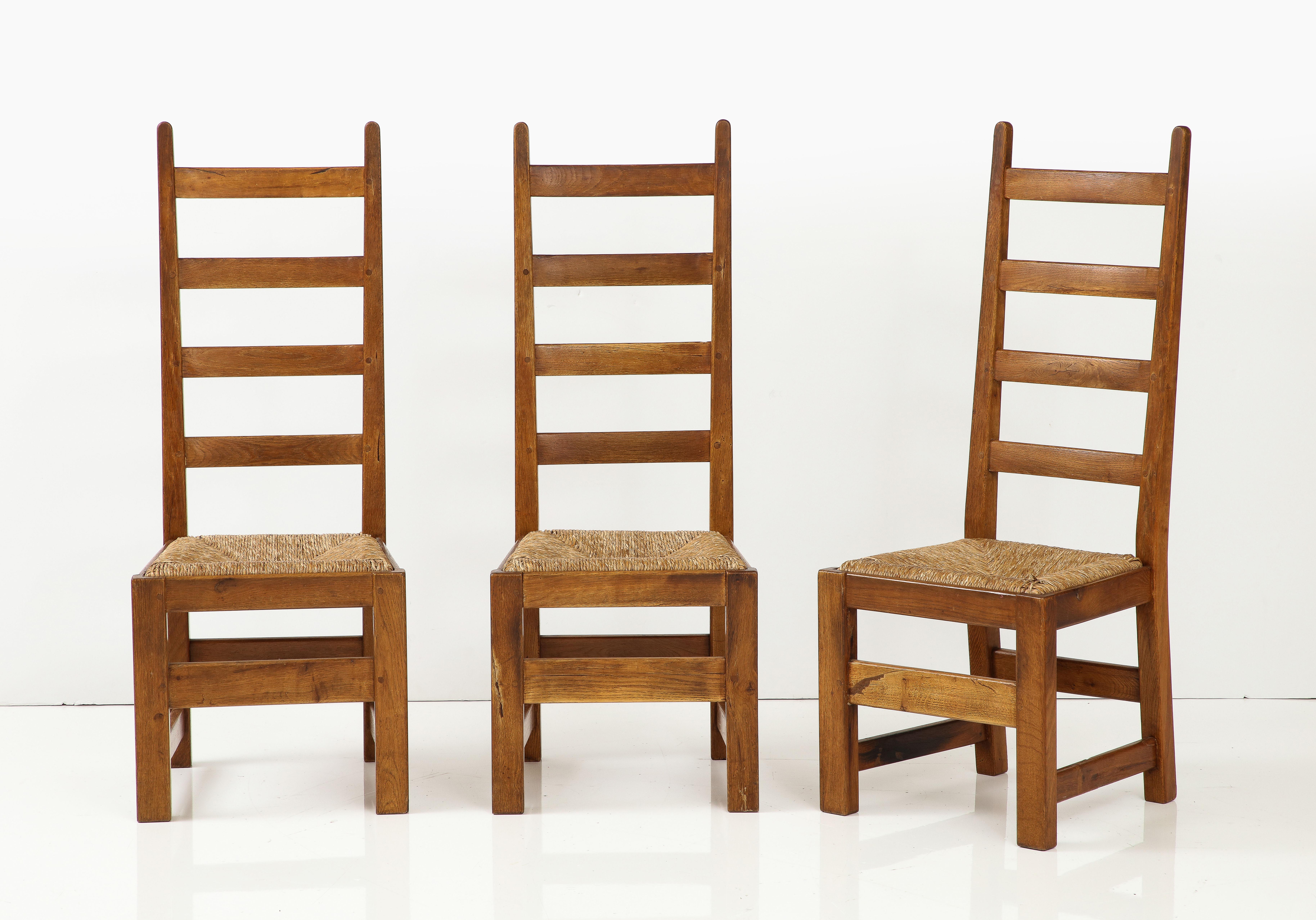 Ensemble de six chaises modernes rustiques en chêne français et jonc avec dossiers hauts, c. 1950, signées
Chêne, jonc

Siège h : 17.75 in.
46 ¾ in. x 18 ½ in. x 17 in.