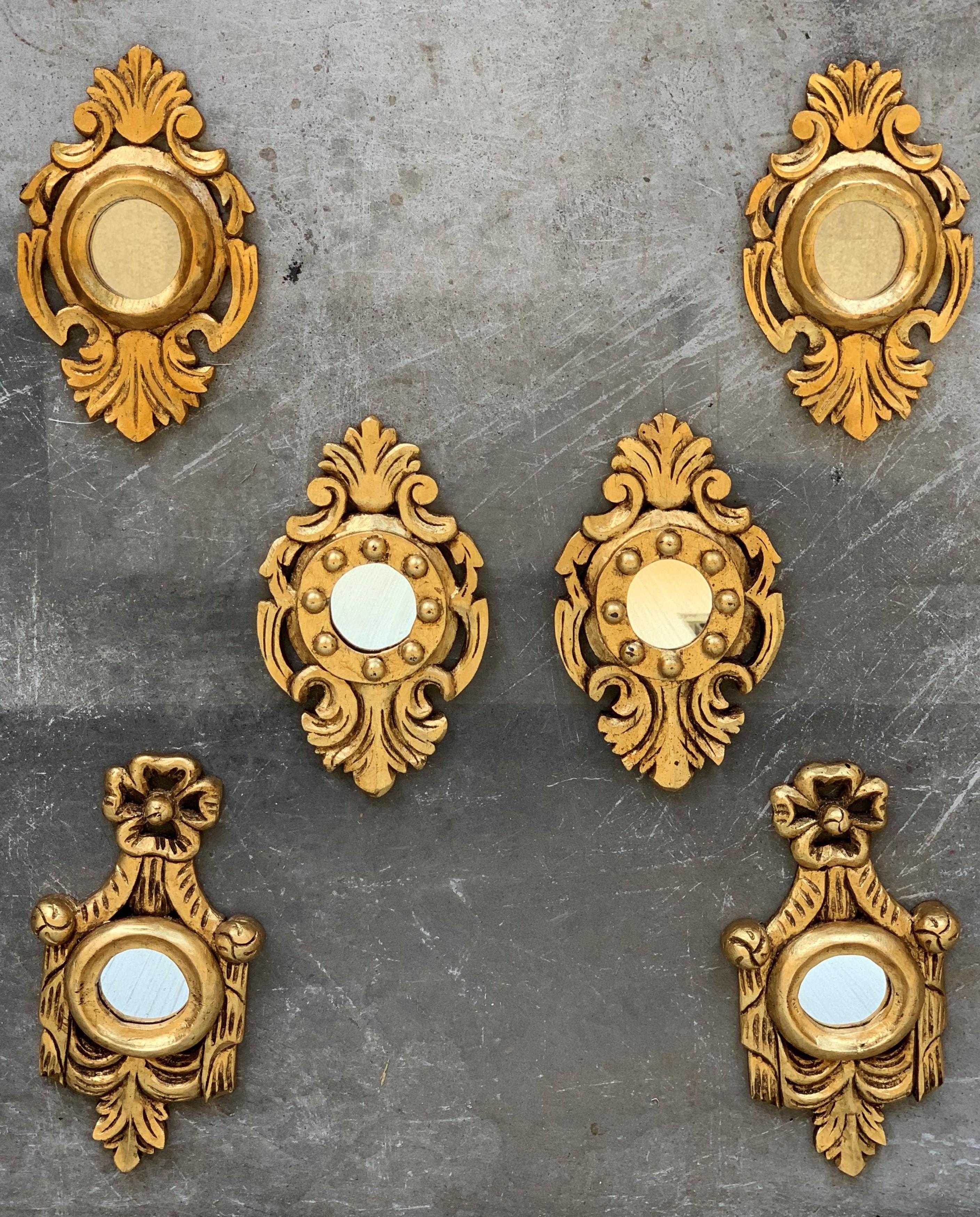 Exquisite Rococo style miniature carved mirrors with a crest on the top and carved naturalistic details at the frames. These pieces are unusual due to their size, they wear their original glasses and they are made of carved wood, gesso and 24-karat