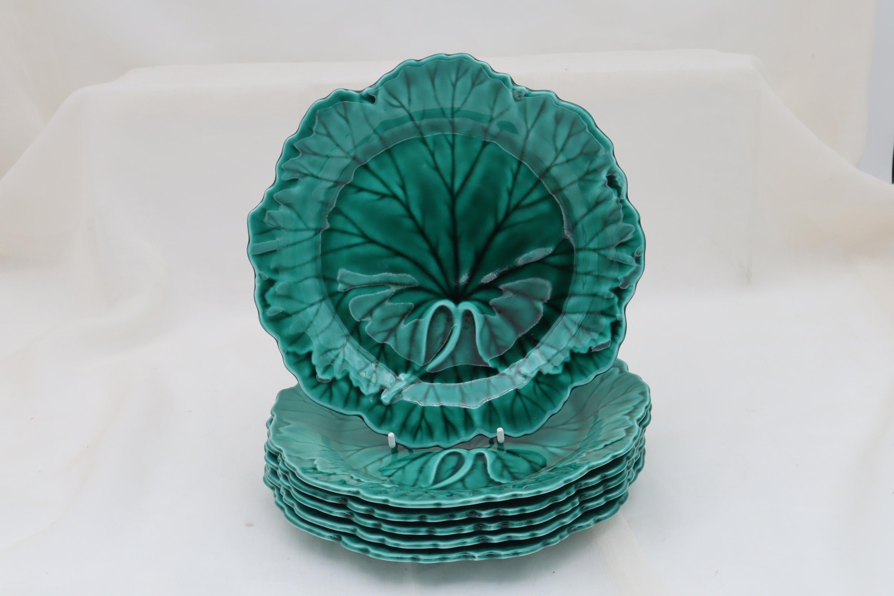 Un ensemble de six assiettes Wedgwood décorées d'un motif moulé d'une feuille de chou et d'un bord panaché, recouvertes d'une glaçure majolique verte transparente. Ils mesurent 200 mm (8 pouces) de diamètre et 20 mm (0,75 pouce) de hauteur. Ils sont