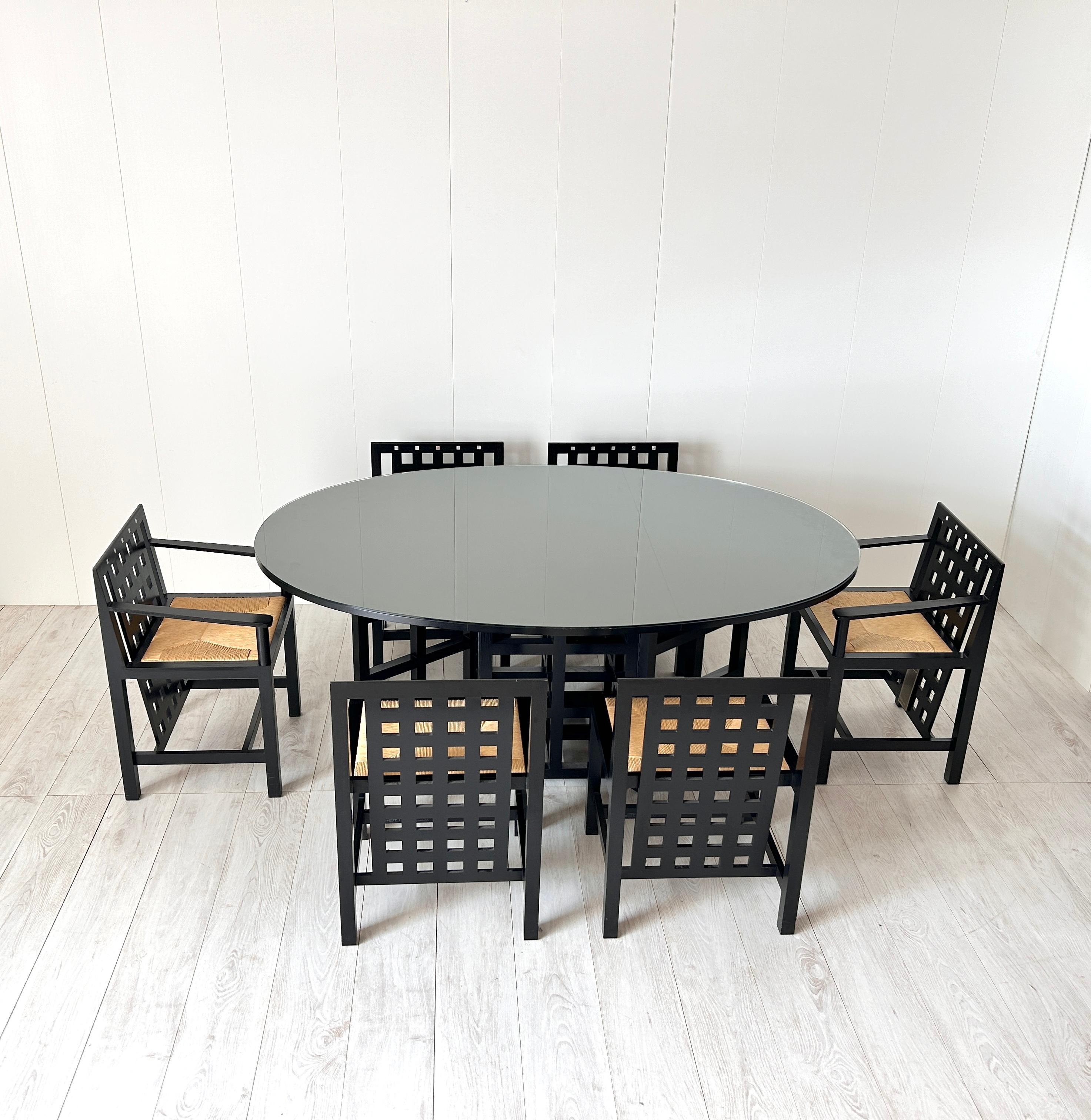 Raro set da pranzo firmato Charles Rennie Mackintosh e prodotto da Cassina nel 1975
Tavolo di forma ovale di importanti dimensioni 
Sei sedie di cui due con braccioli (capitavola)
Tutte le sedie sono marcate e numerate
Etichetta originale
