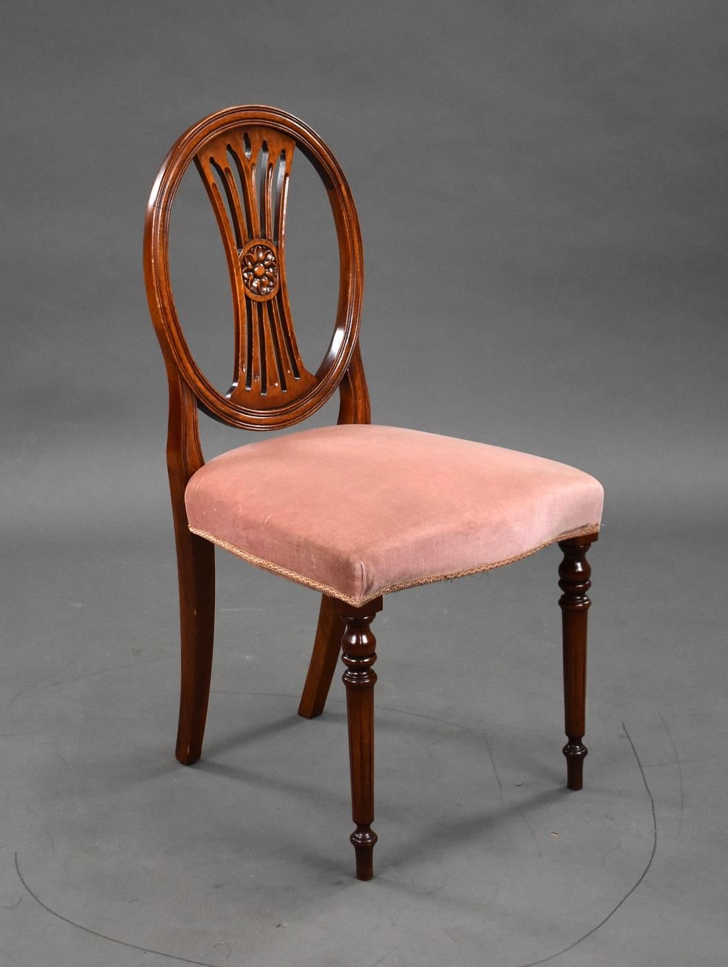 Set ten 20th century Mahogany dining chairs in good condition. The set comprises of eight singles and two carver chairs, the chairs have oval backs with carved motif to the centre standing on turned legs. The chairs have stuffover seats in a pink