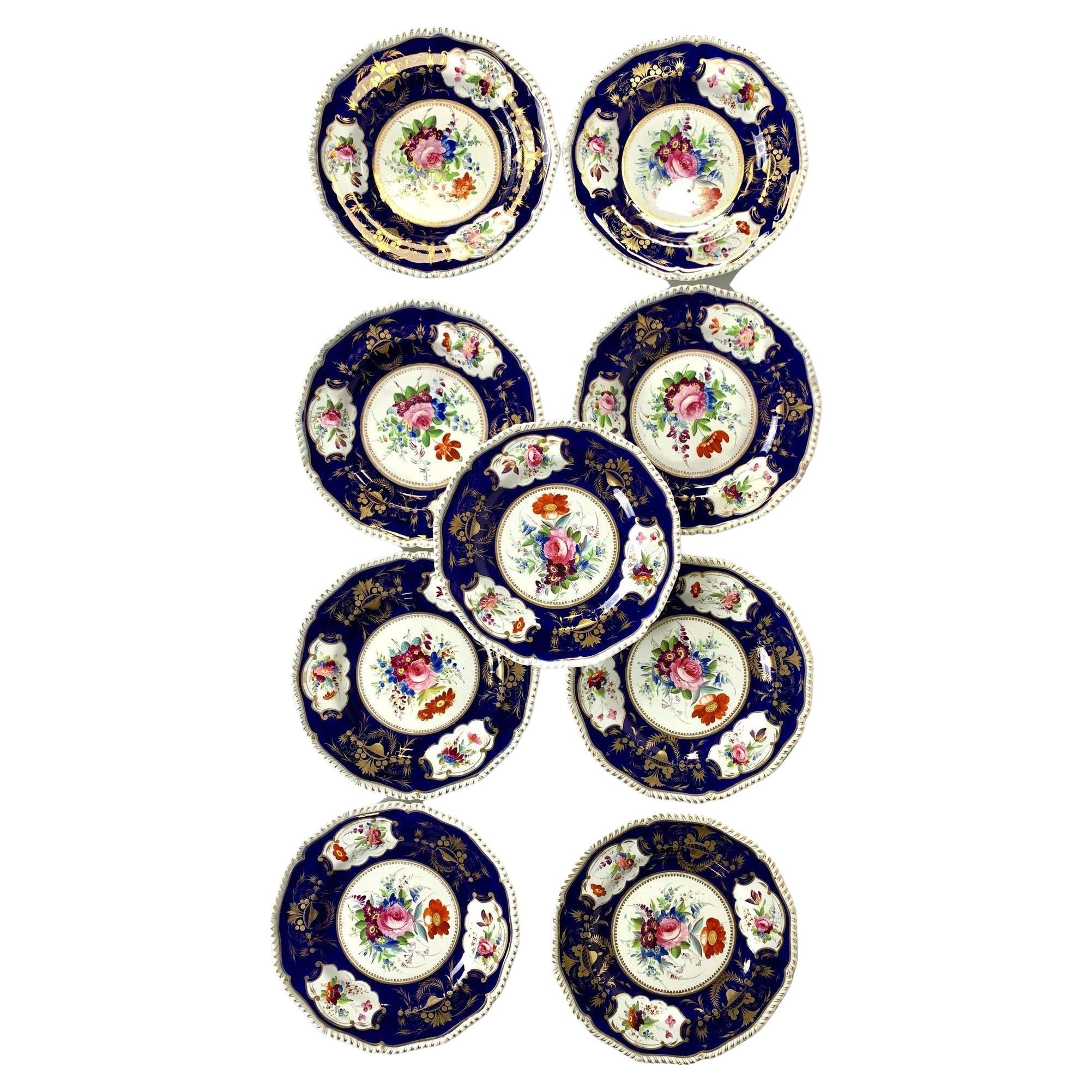 Each plate in this set of ten Derby dinner plates was hand painted with exquisite flowers in England circa 1825-1830.
In the center of each plate, we see a loose bouquet of flowers, including pink roses, purple and yellow auricula,
blue