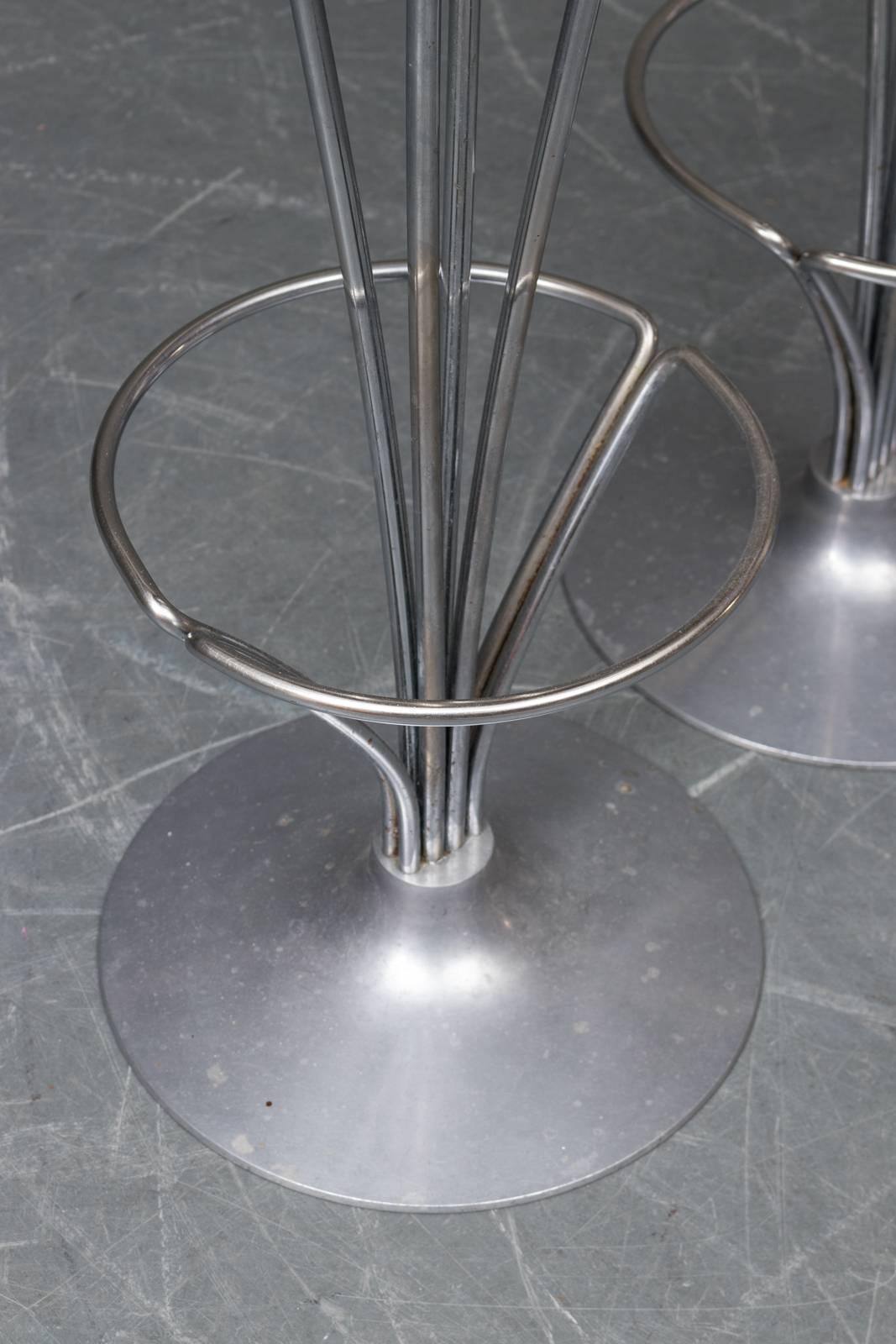 Set of three Danish Modern, polished aluminium bar stools, designed by Piet Hein and manufactured by Fritz Hansen in 1984, model 9511. Frames are in good condition, some wear to fabric tops consistent with age and use.