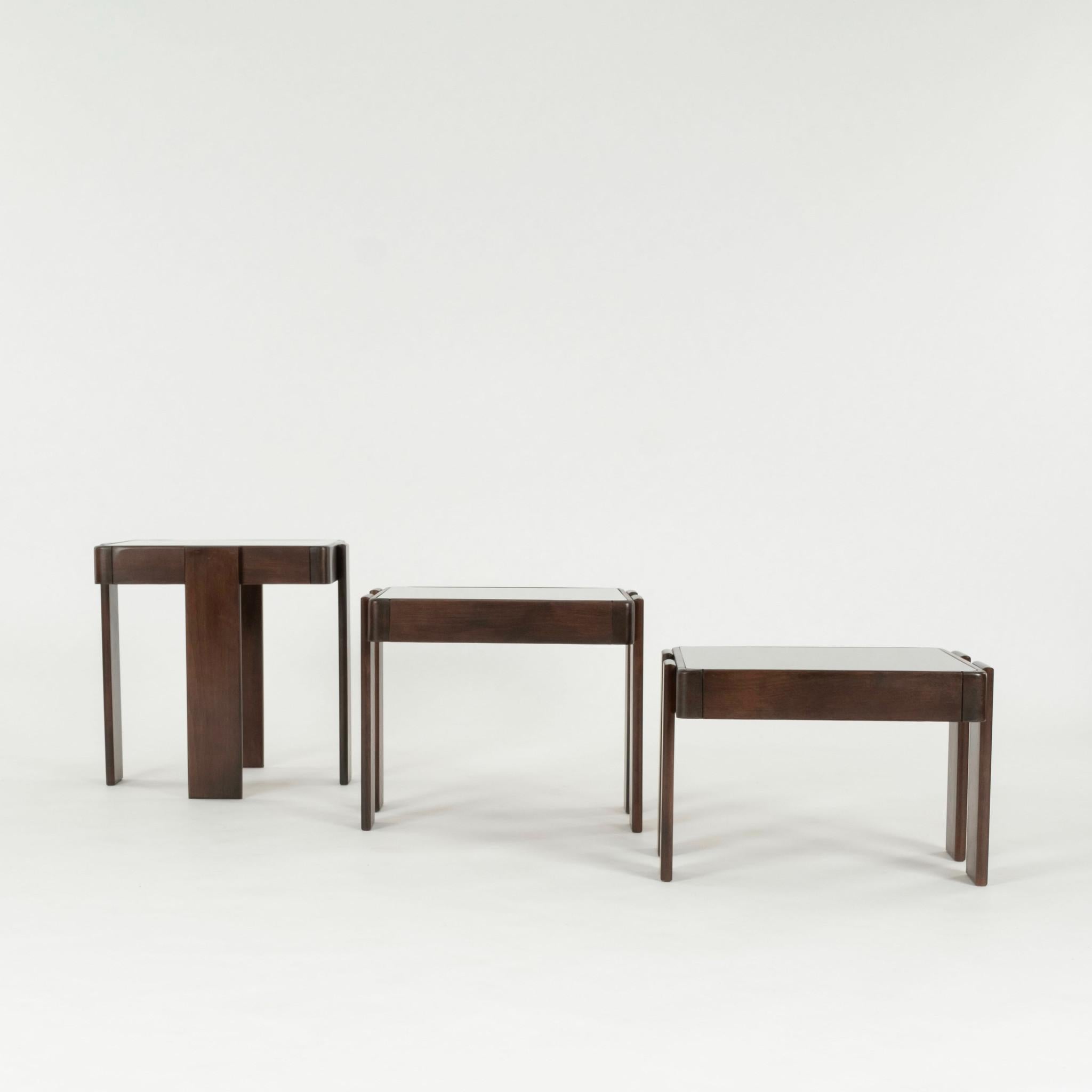 Ensemble de trois tables gigognes en bois de noyer et verre fumé bronze par Gianfranco Frattini pour Cassina.

Gianfranco Frattini (15 mai 1926 - 6 avril 2004) était un architecte et designer italien. Il fait partie de la génération qui a créé le