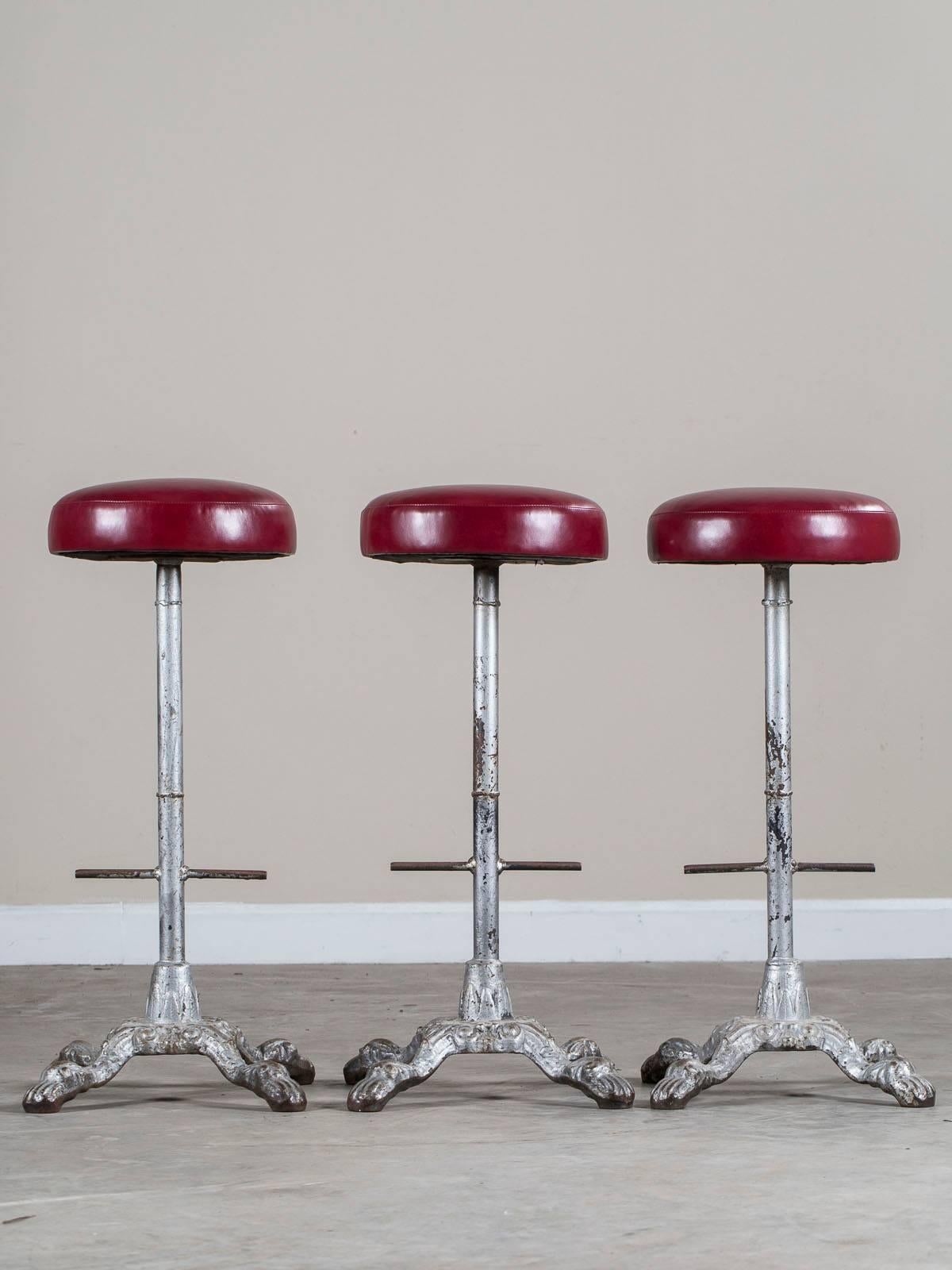 Three vintage English cast iron stools from England, circa 1895. These counter height stools retain their original painted finish that shows the passage of time. The use of cast iron that originated in the nineteenth century literally changed the