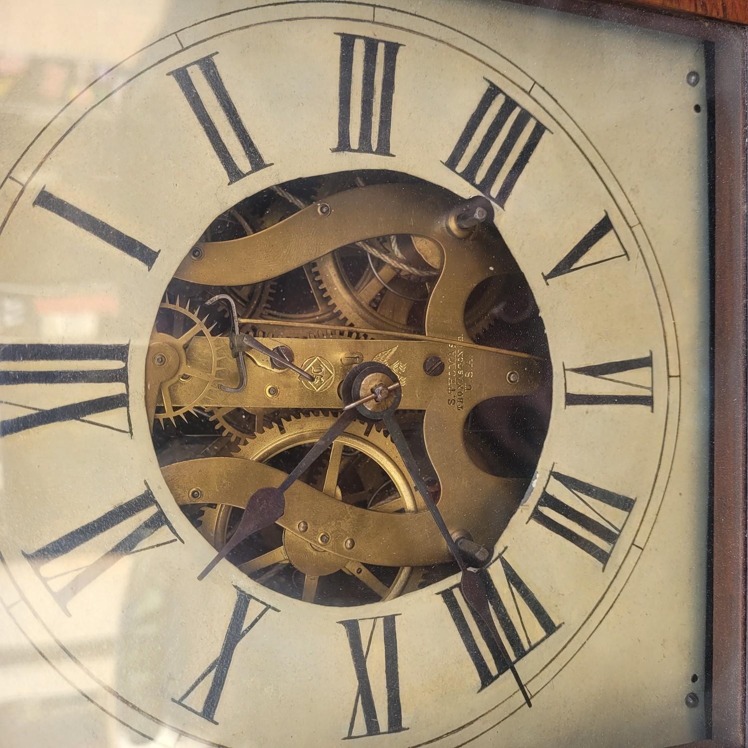 Rosewood wall clock, decorated with a mirror and a bird painted with the technique of fixed under glass in the lower part.   
It bears the manufacturer's labels Seth Thomas, Eight day and weight clocks.   

Seth Thomas (1785-1859) was an American