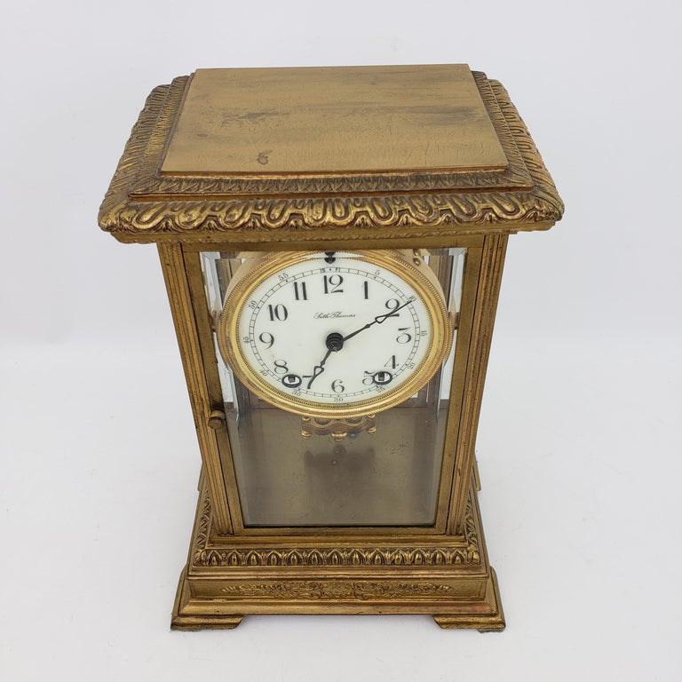 Ornate gilded brass cased mantel clock by Seth Thomas. Recently serviced and working. It has an 8-day time and strike movement with a mercury pendulum and key. It features beveled glass front, back and side panels, hinged front and back doors and a