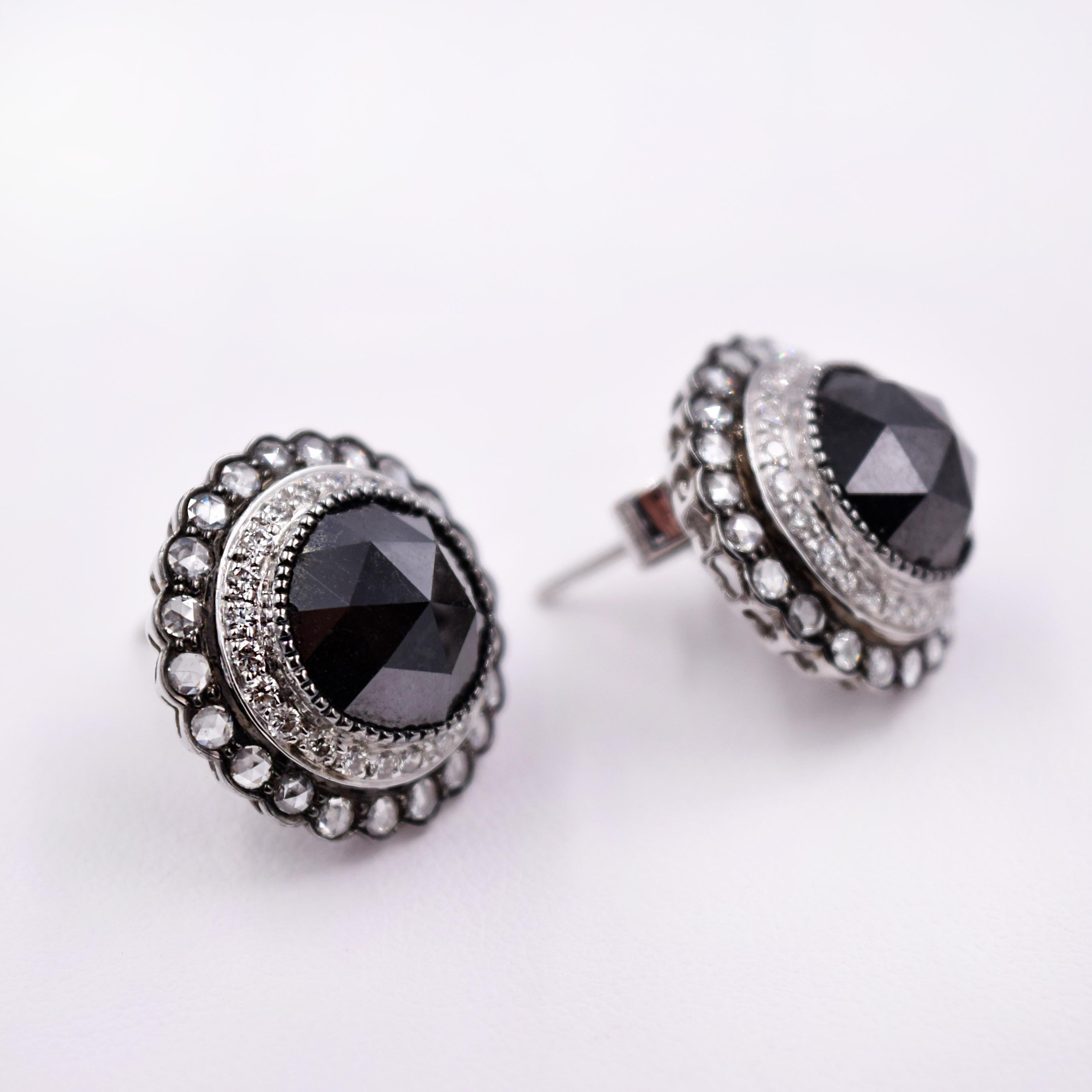 Large 10.75ct total weight rose cut Black Diamond Stud Earrings. 
Center Black Diamonds are set in a Millgrained Bezel with a double halo of full cut and rose cut White Diamonds. Beautiful in every way with a Vintage inspired look. 
Set in 18K White