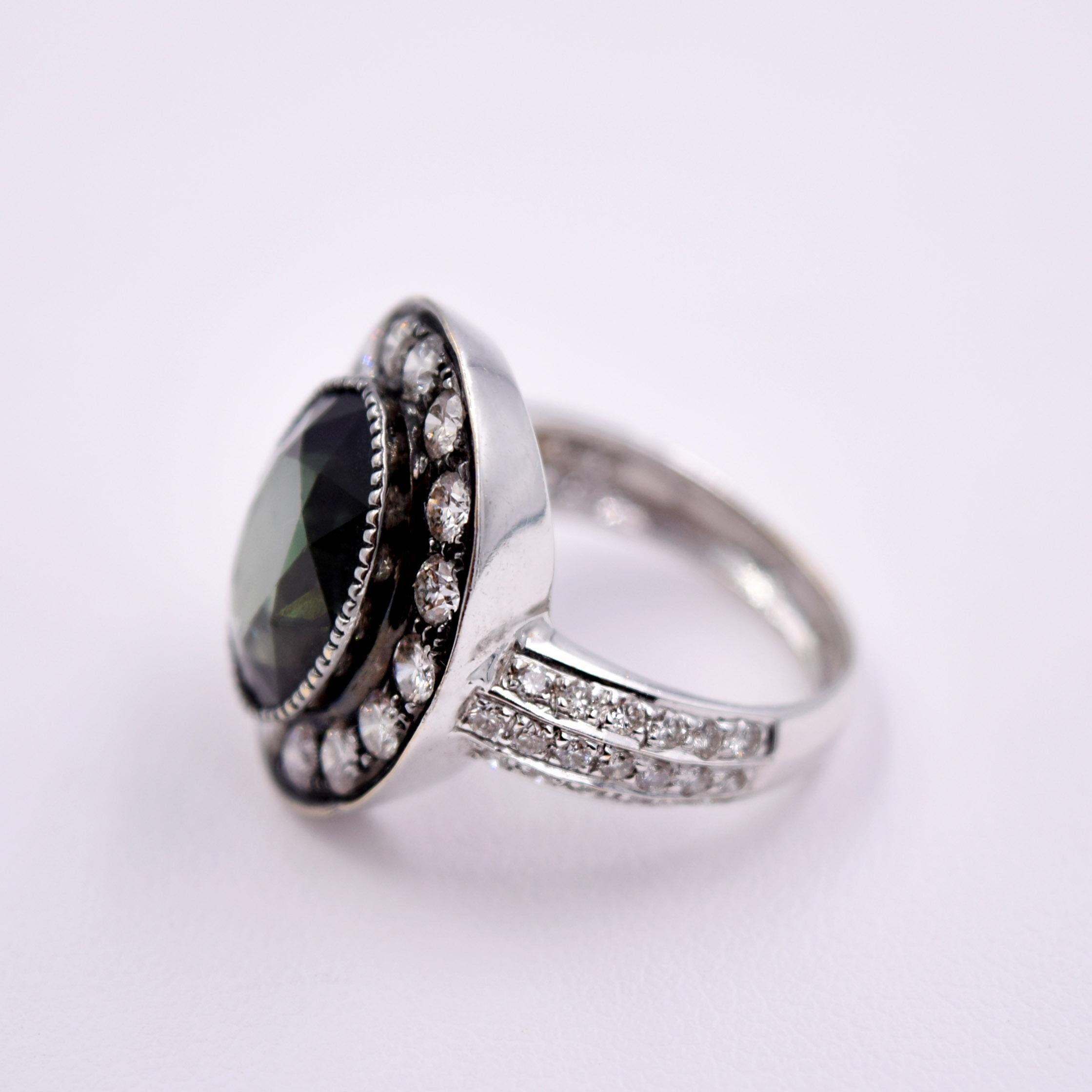 A gorgeous 5.5ct deep green oval shaped Tourmaline is featured in this vintage inspired design by Sethi Couture. 16 Brilliant White Diamonds surround the Green Tourmaline, bringing this beautiful Cocktail Ring to life. Three rows of smaller White